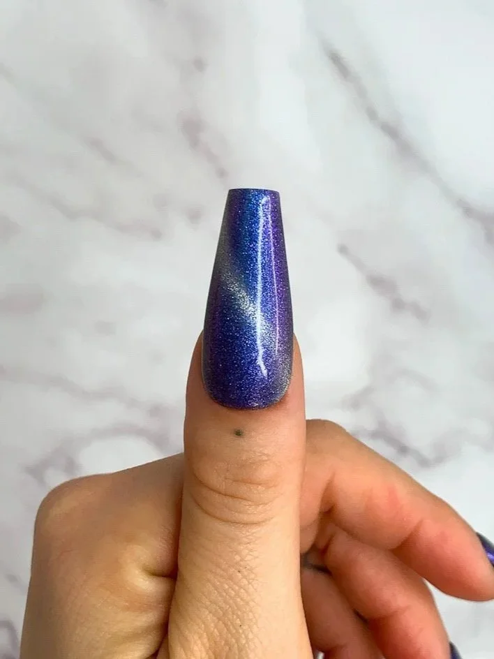Long coffin press-on nails in navy and black galaxy pattern.