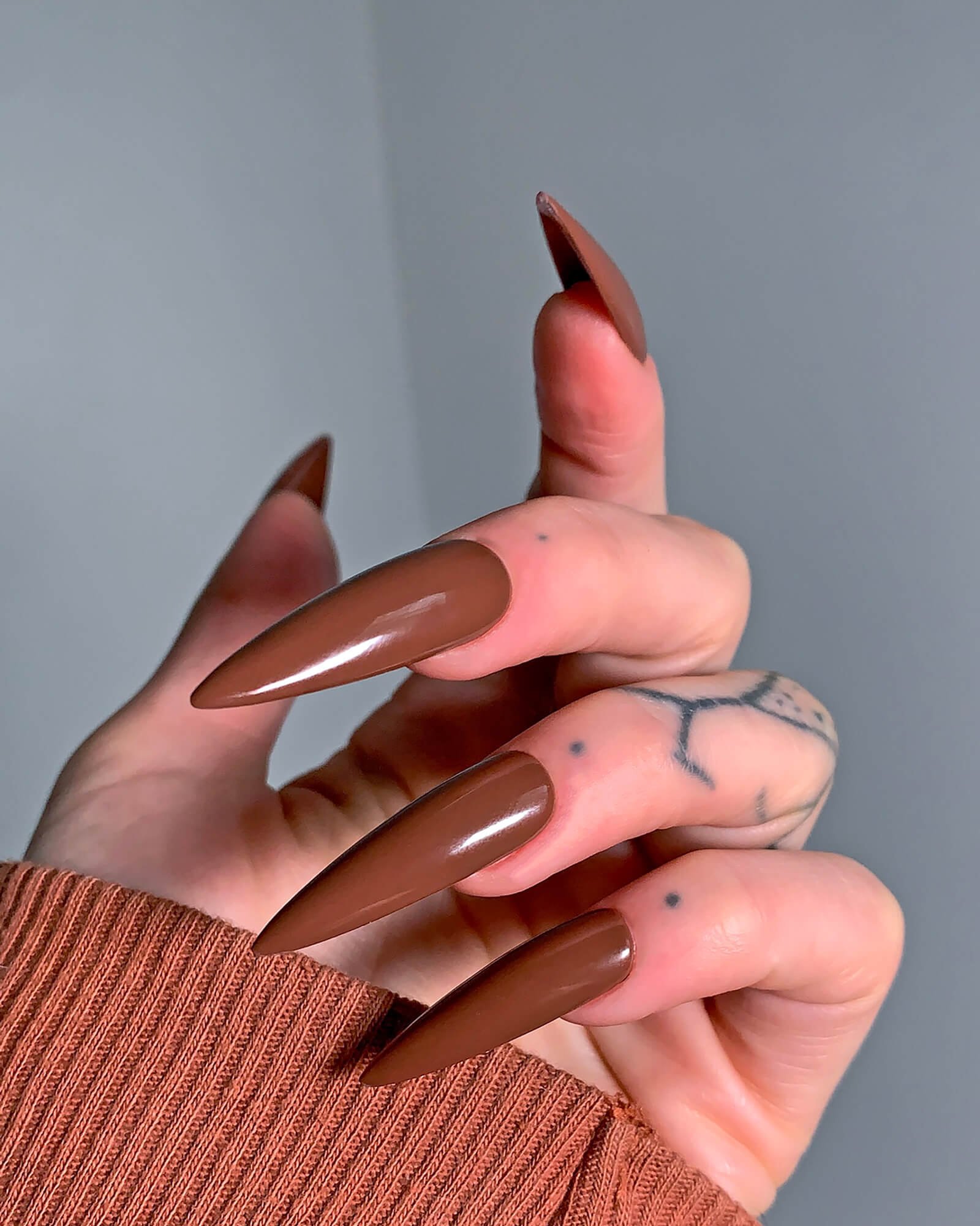Model wearing the hand-painted press-on nail set in brown espresso color.