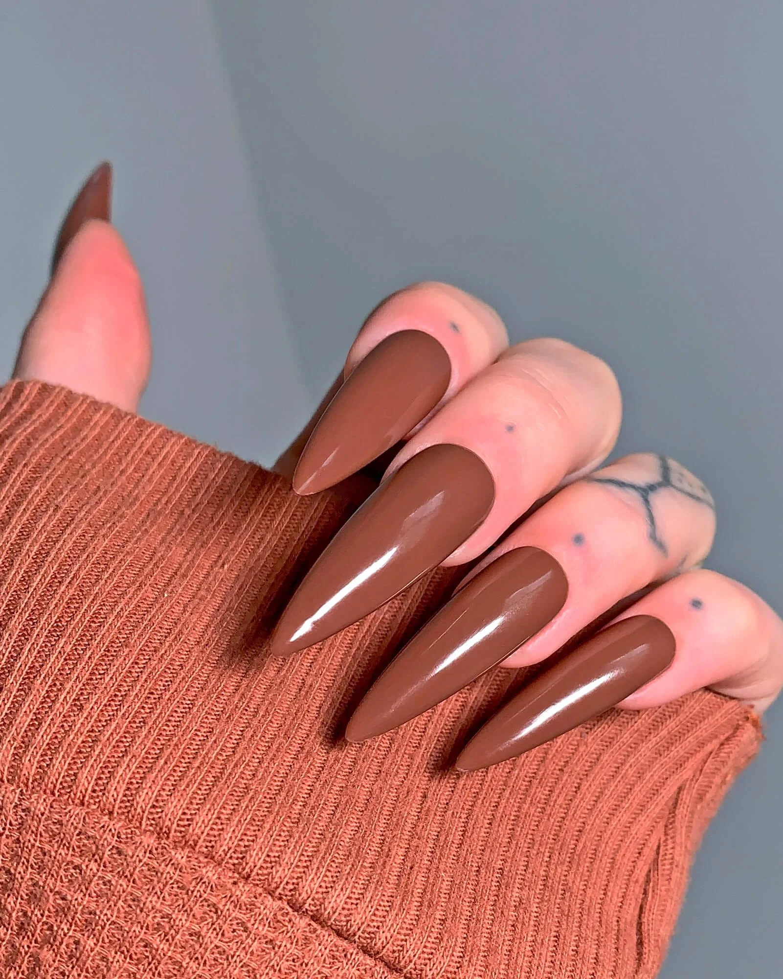 Simple press-on nail set in espresso color on a hand model.