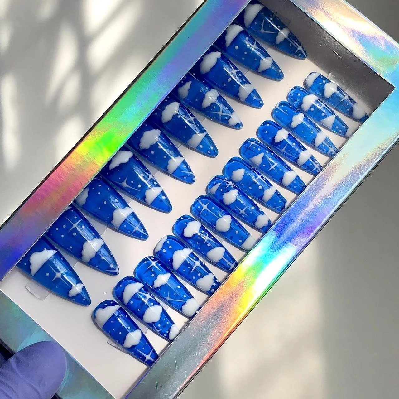 Set of hand-painted blue jelly press-ons with hand-painted clouds, stars, and glitters.