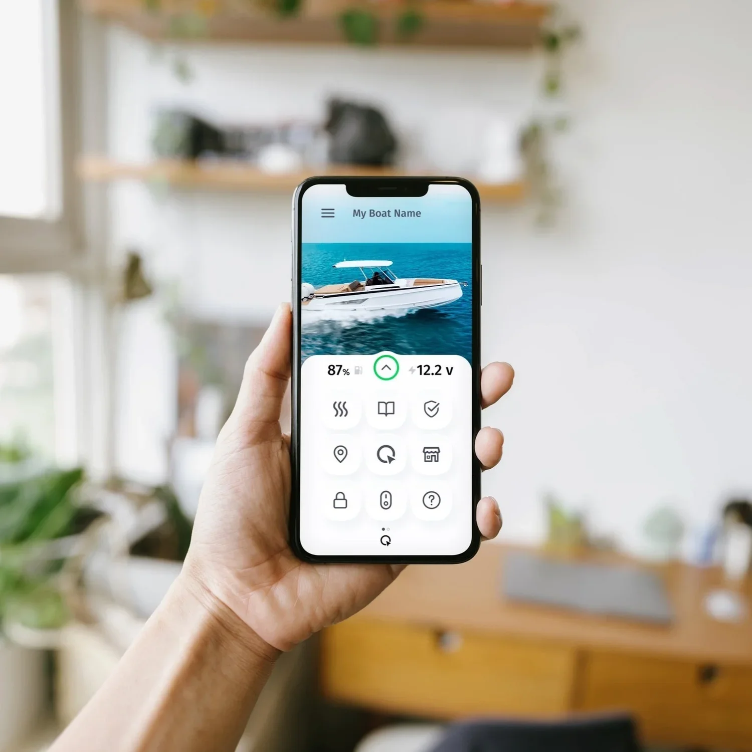 A hand holding a Q App at home