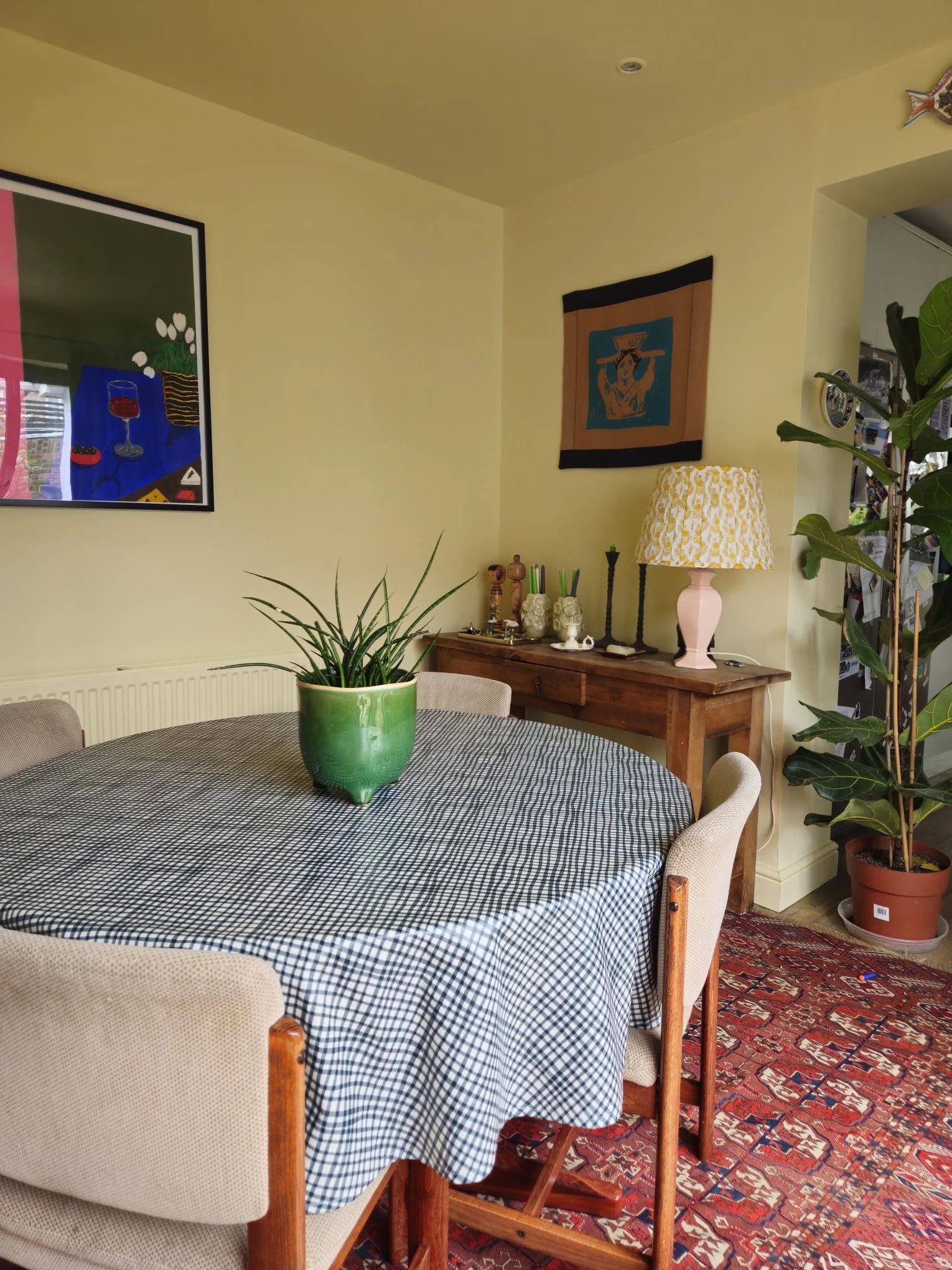 The yellow dining room. The space in between the kitchen and living room needed to feel fresh and uplifting. The wall covering, artwork, antique rug and accessories bring colour, pattern and interest.