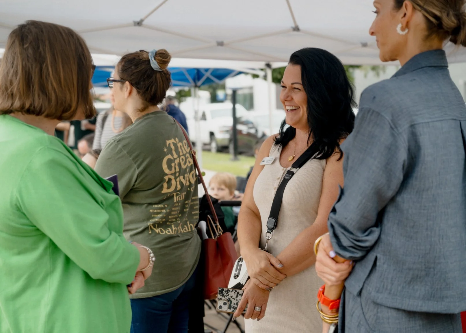 Participants talking beneath a canopy at the Cures Can’t Wait mural gathering.