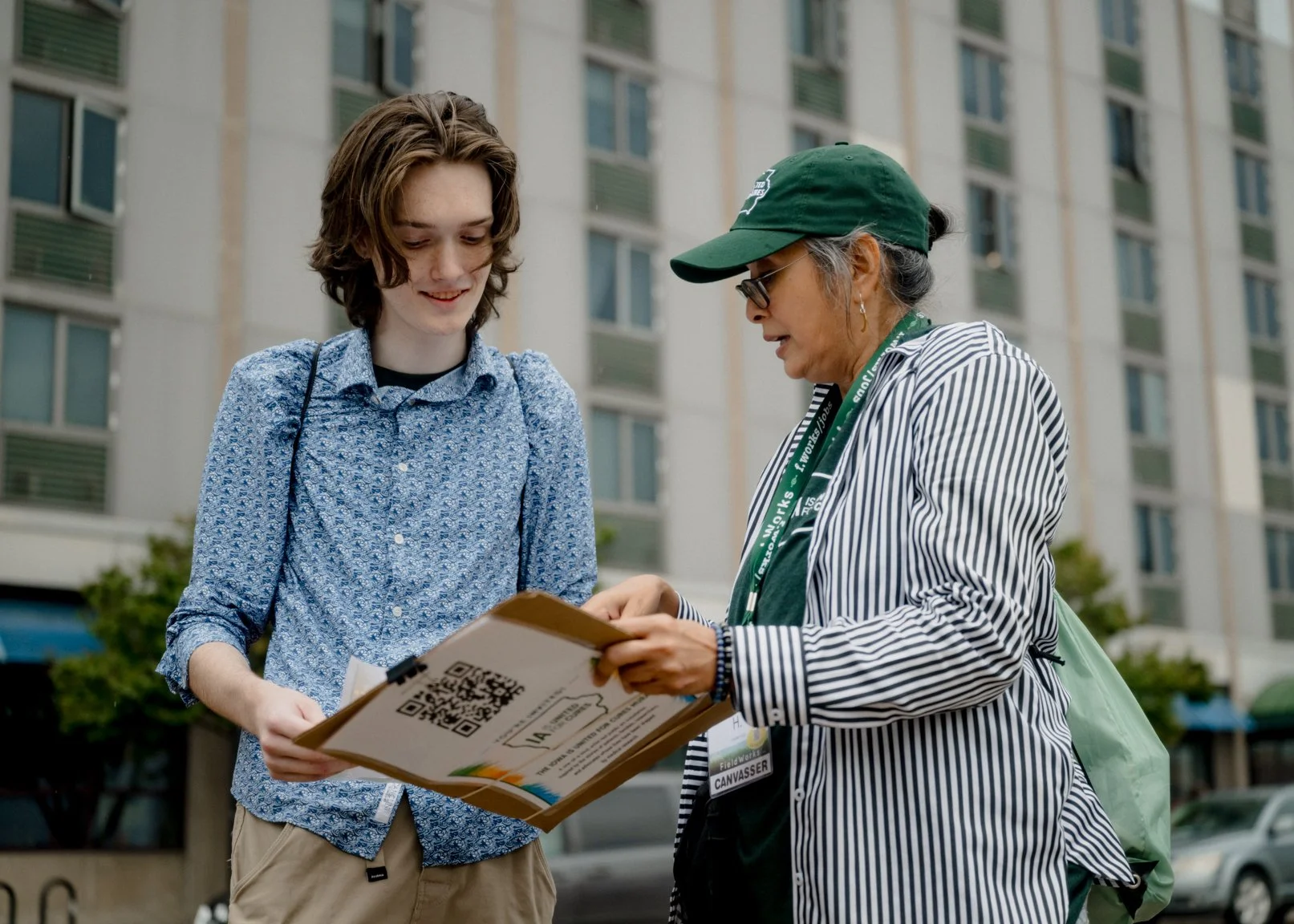 Two people looking through printed materials at the mural gathering.