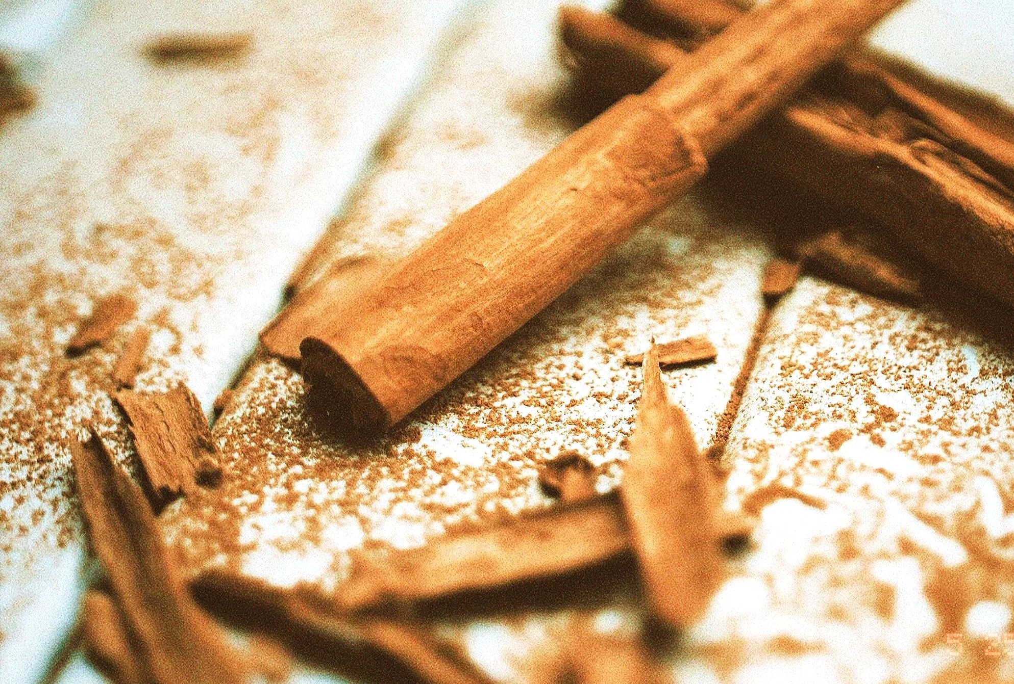 Close-up of cinnamon sticks and ground cinnamon on a surface.