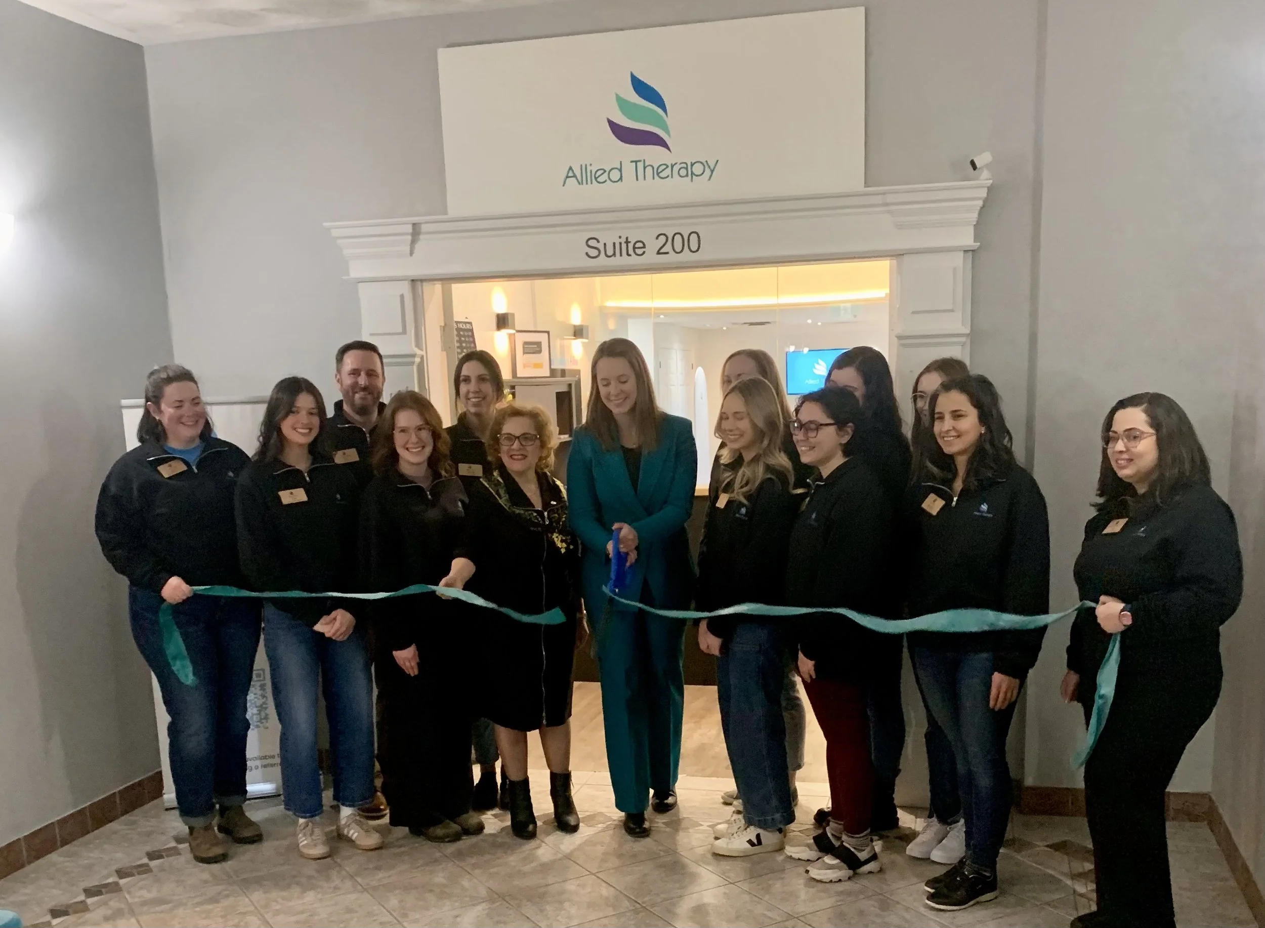 Image of cutting the ribbon outside the physical suite for Allied Therapy