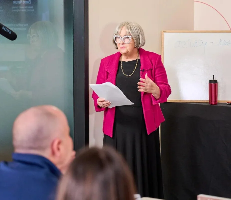 Dalene speaking in front of a room of people