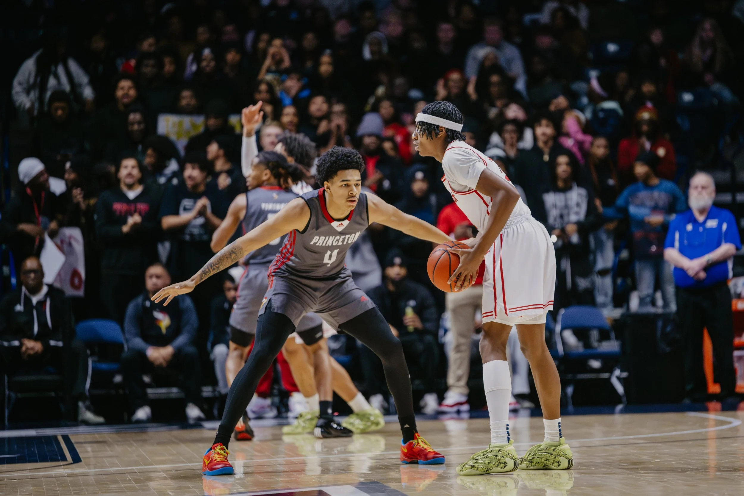 Princeton Vikings number 4 Kam Mercer in defensive stance guarding a Lakota West player holding the basketball with a packed Cintas Center crowd in the background