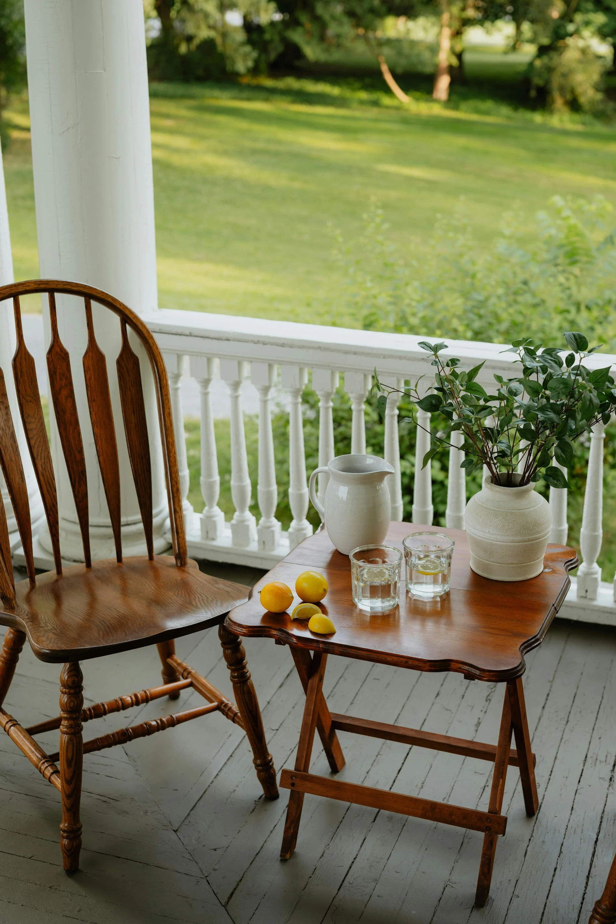 Two wooden porch chairs with drinks and plants symbolizing companionship, respite care, and supportive home services.
