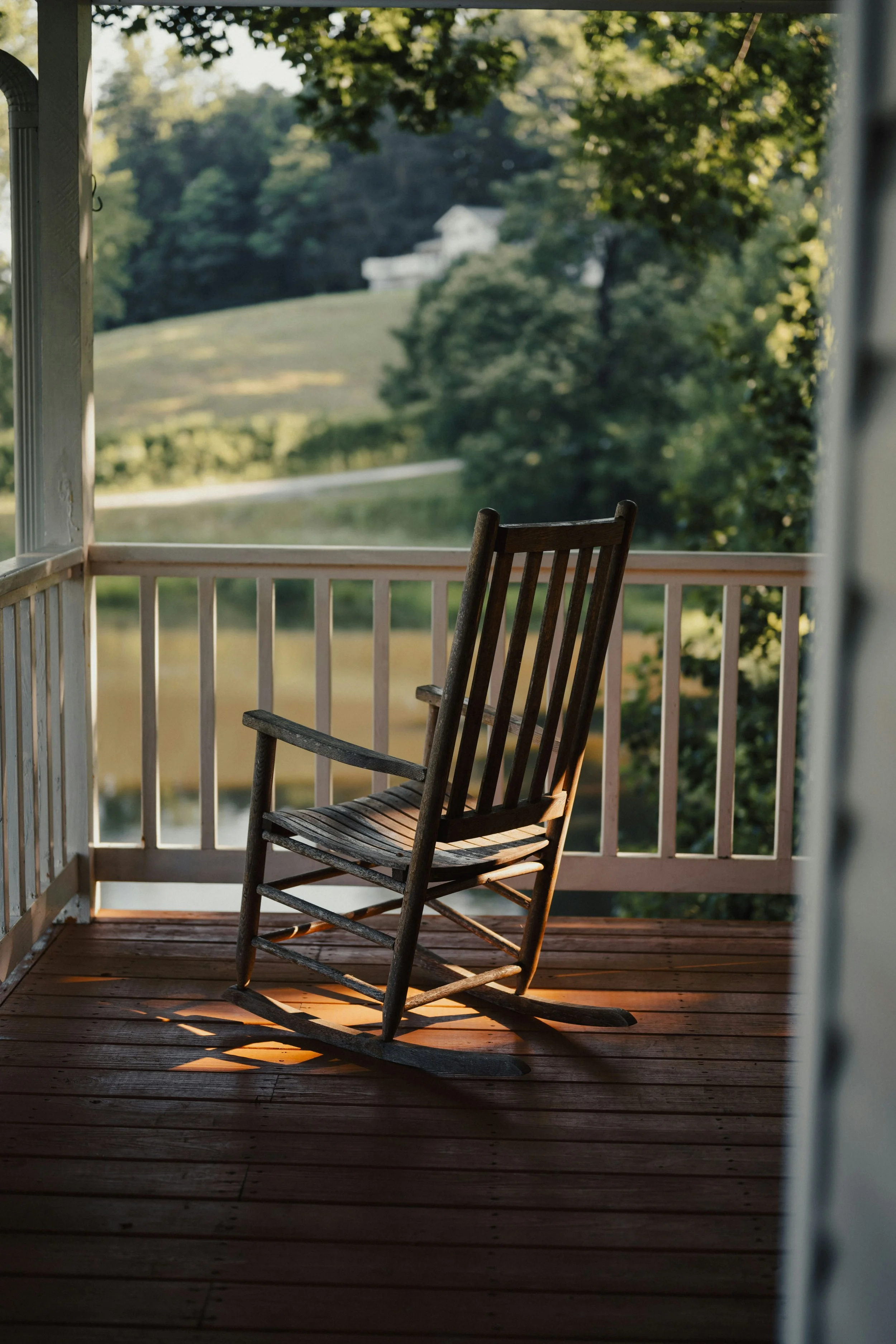 Wooden rocking chair on a peaceful front porch at sunset representing comfort and aging-in-place support.