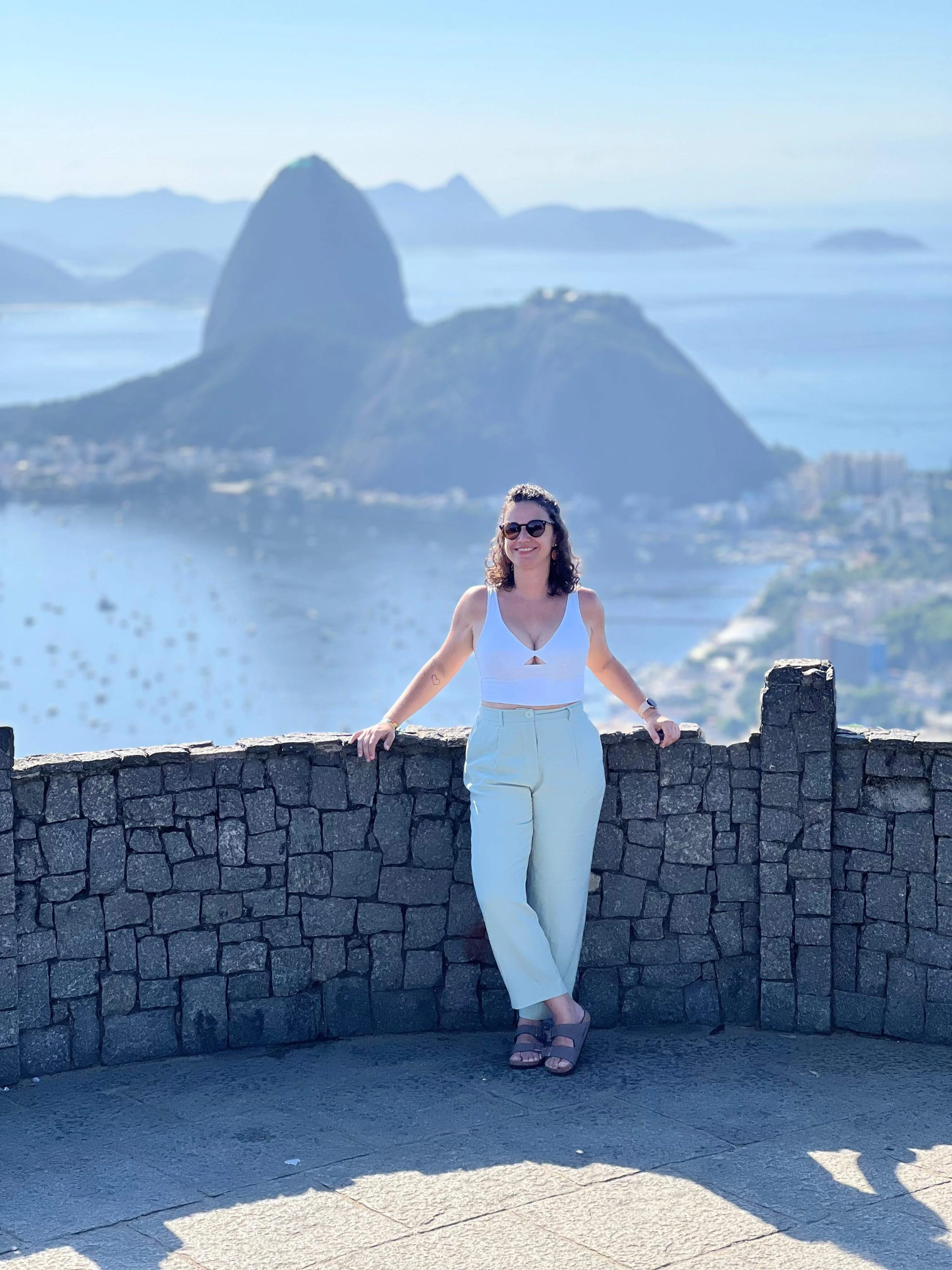 Image of a girl from Rio de Janeiro standing at a viewpoint overlooking the Guanabara Bay and the Sugar loaf