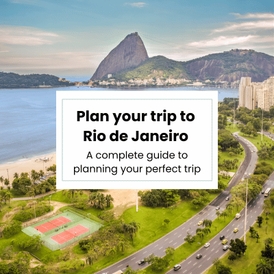 Aerial view of Rio de Janeiro featuring Sugarloaf Mountain, beachfront, and city roads along the coast.
