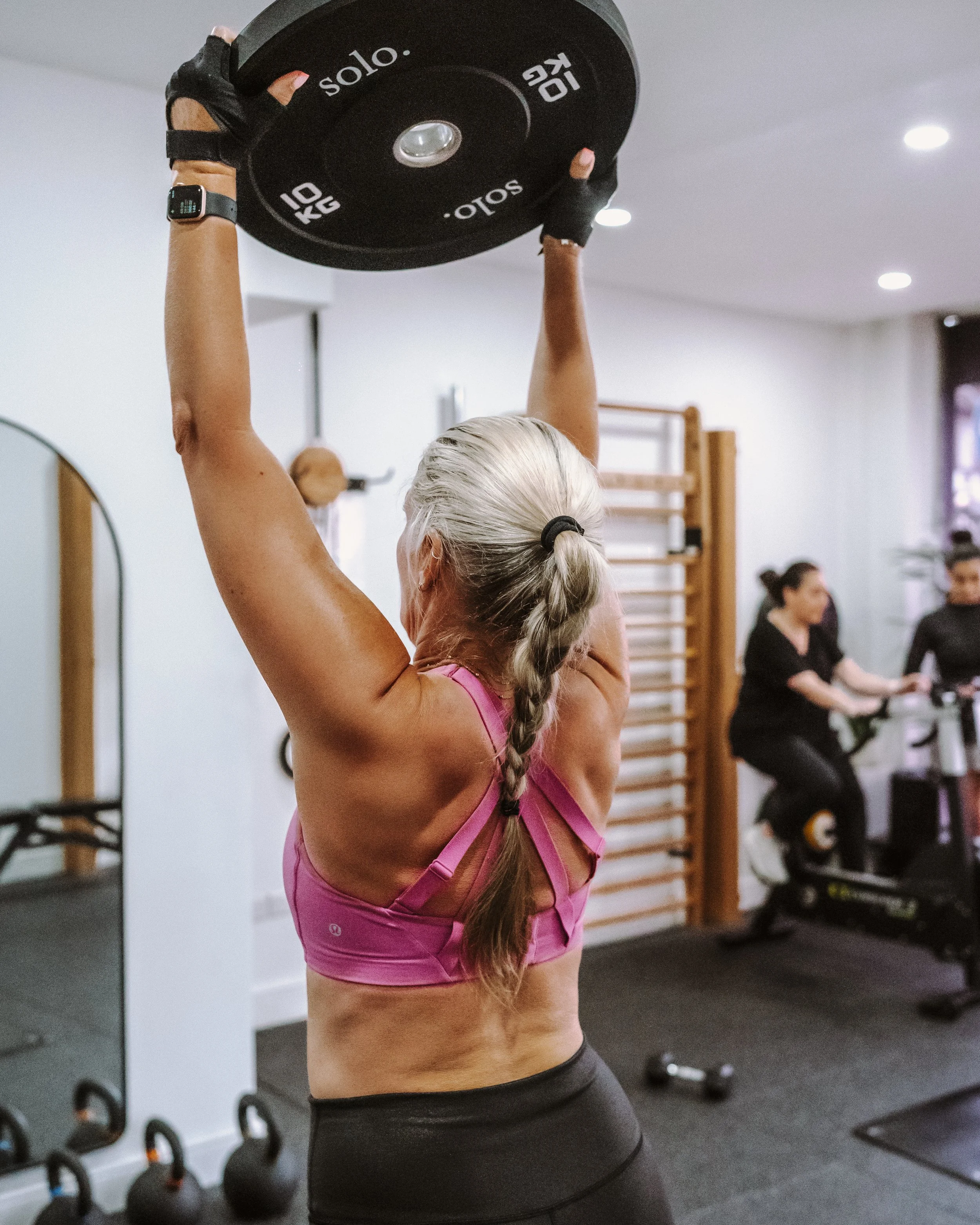 A member weight training and building muscle at SYNQ Studios.