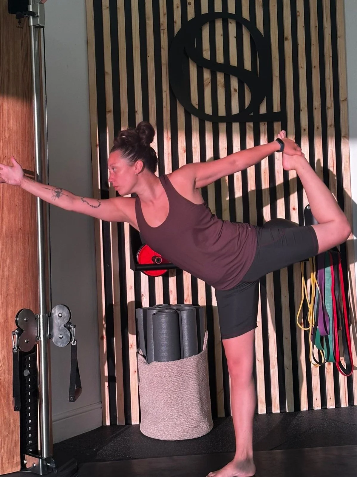 Woman practicing yoga outdoors with her hands pressed together in a prayer position, facing forward against a clear sky.