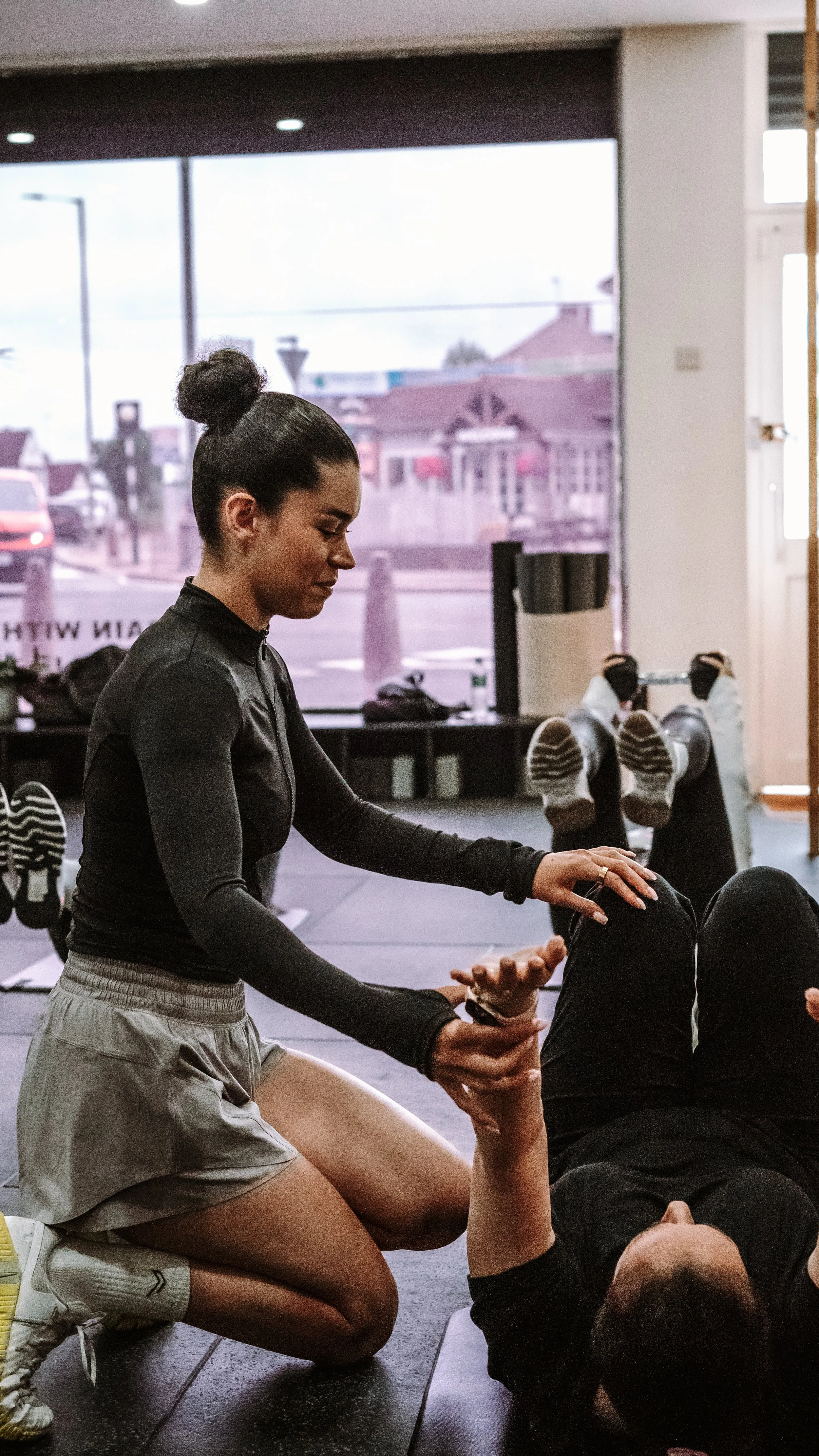 SYNQ Studios coach providing hands on guidance during a small-group personal training session in Edgware, near Mill Hill