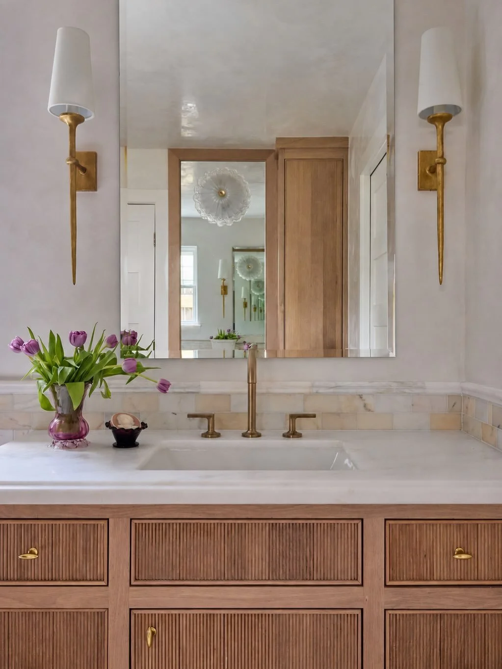 Blush and brown, 
🤎🩷FOREVER🤎🩷.

We love the way the Calacatta Evora marble wraps the walls and floor in blush tones and chocolate veining, while antique lighting sparkles against Venetian plaster.

The off-the-cuff decision? Mounting a Murano gla