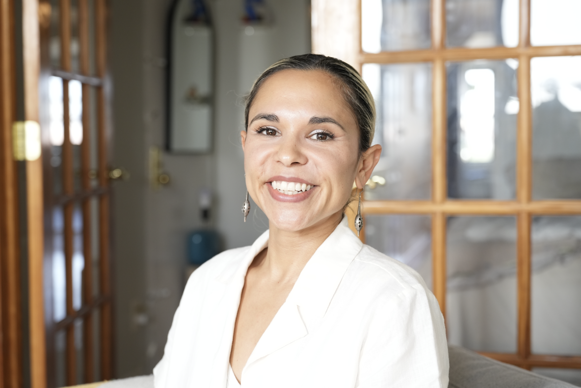 Warm, welcoming portrait of a Latina somatic therapist in NYC, providing luxury-level, queer-affirming therapy for ambitious professionals wanting deeper alignment and nervous-system healing.