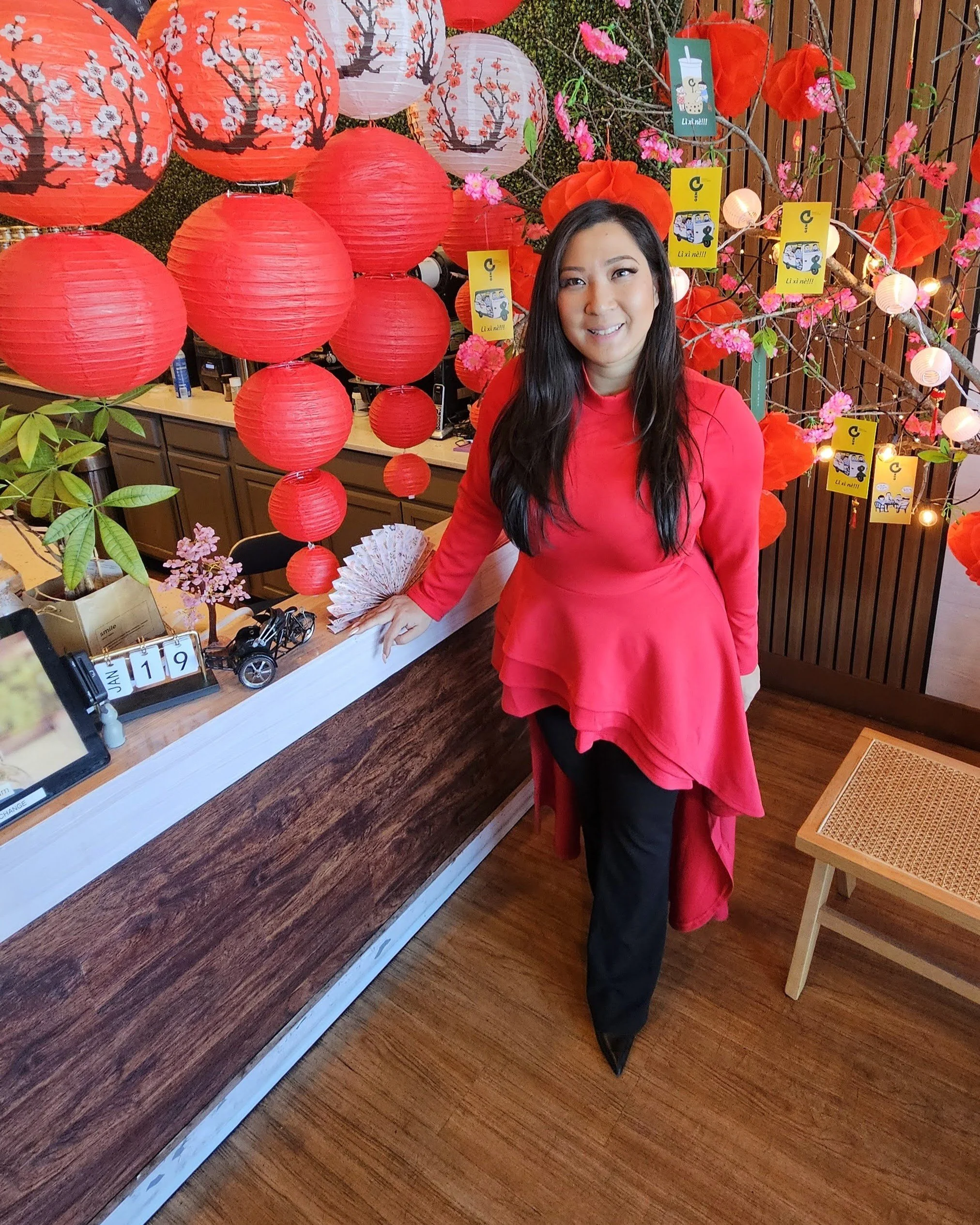 Rebecca Le, founder of ATX Asian Food and content creator behind TheHonestFoodist, stands at Gen Bobabee in Austin, Texas, surrounded by red lanterns and Lunar New Year decorations, spotlighting Asian-owned businesses and community storytelling.