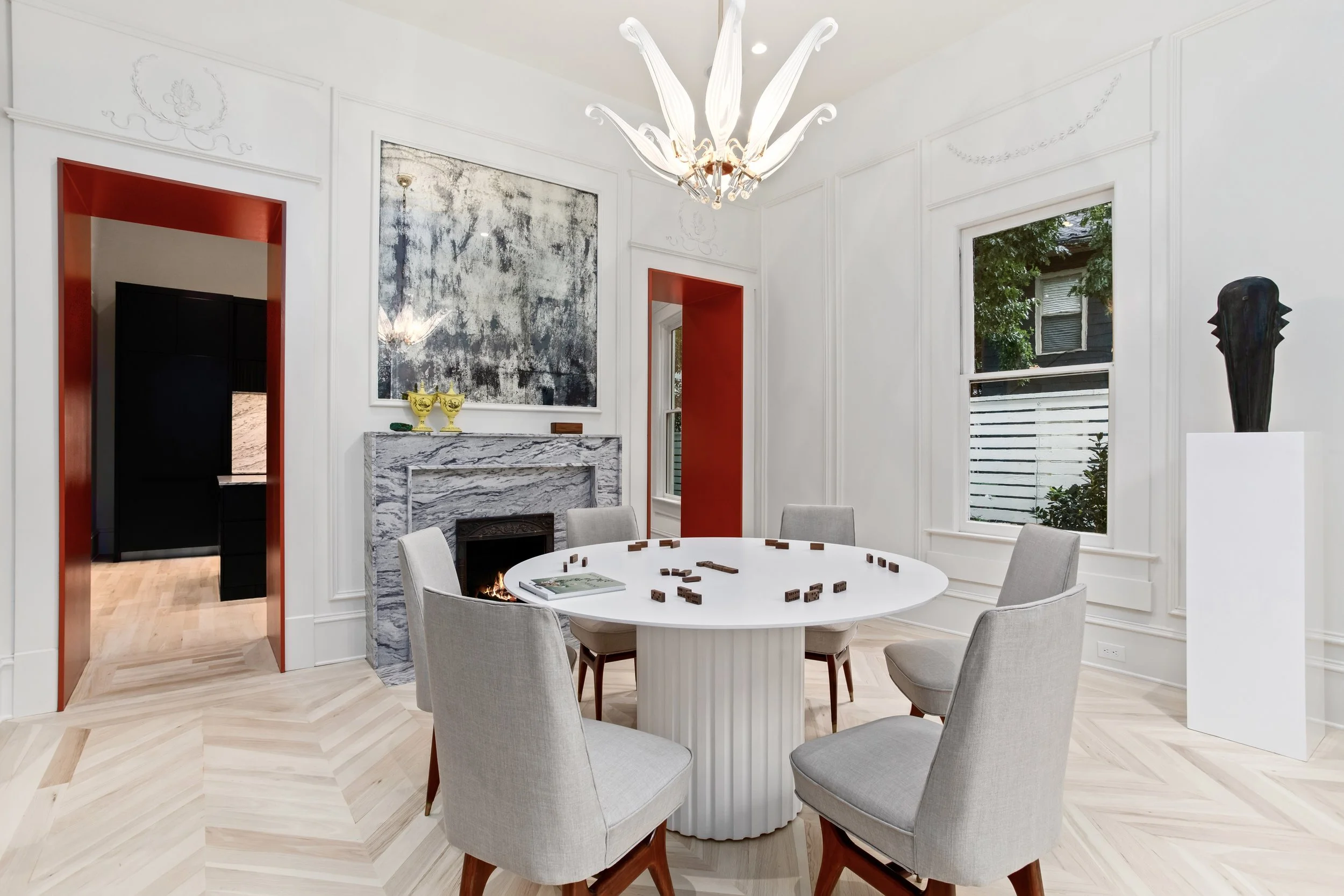 With the kitchen relocated to what was formerly a bedroom adjacent to the dining room, opening the wall to create two generous passageways was a natural choice, strengthening the connection between the spaces. An accidental demolition of the original