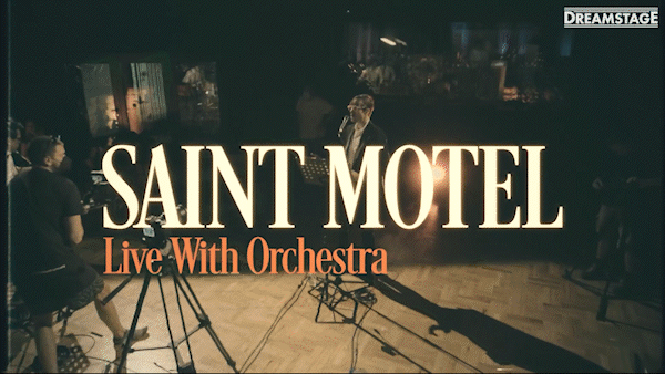 Promotion for Saint Motel's live performance with orchestra, featuring a stage with musicians and a conductor.