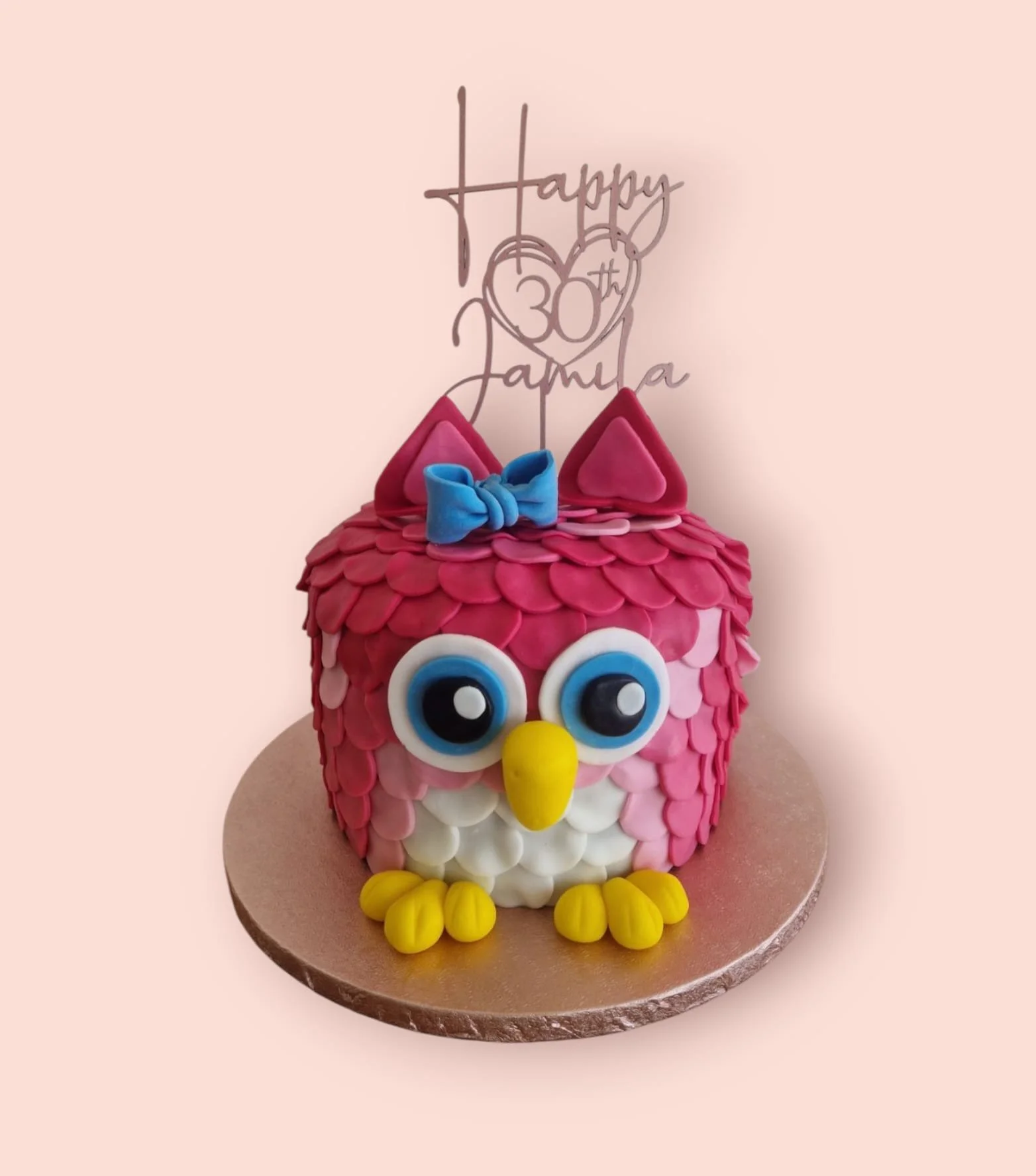 Bunte Geburtstagstorte in Form einer Eule mit grossen blauen Augen, gelben Füssen, pinken Ohren und mit einem blauen Schleifchen zum 30. Geburtstag.