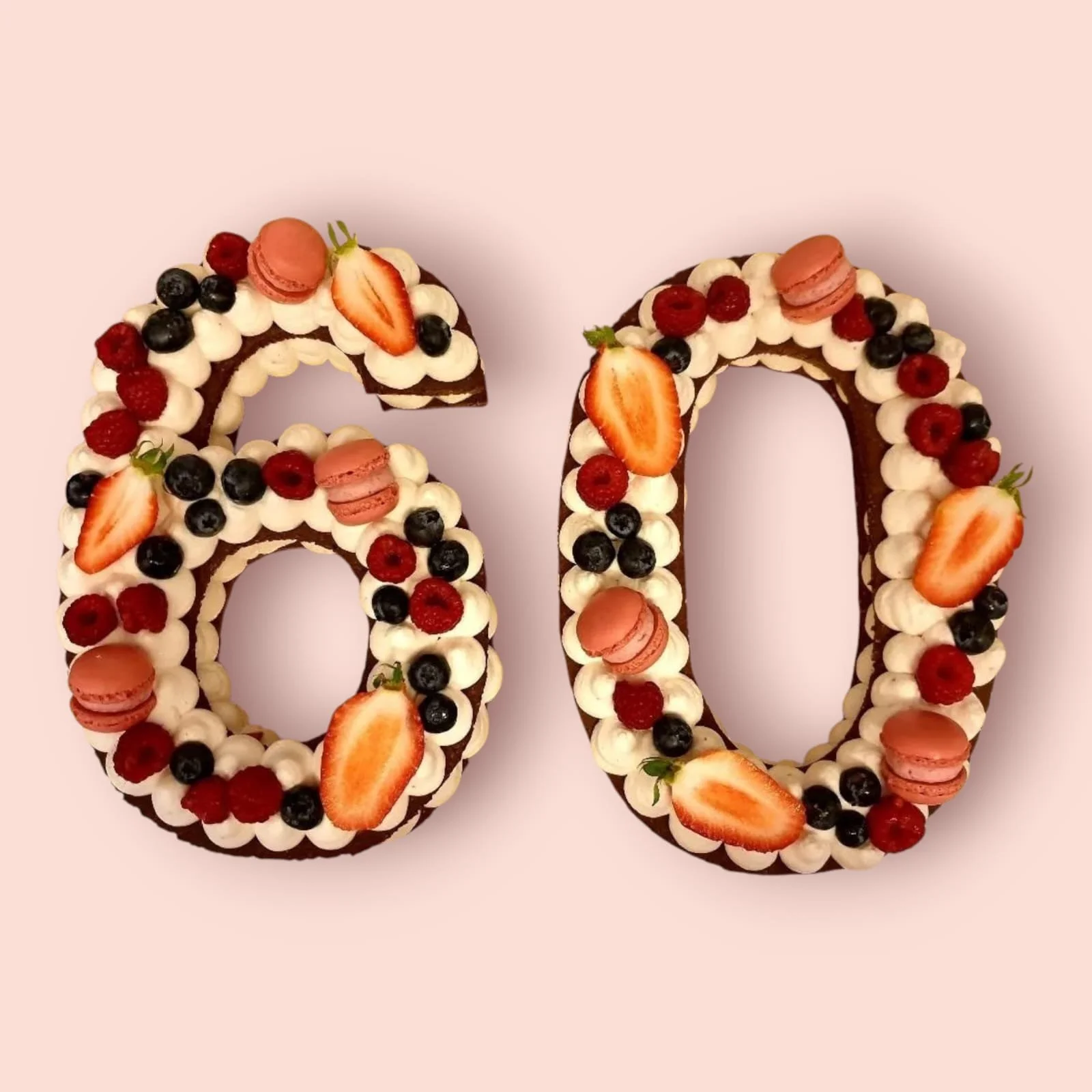 Numercake zum 60. Geburtstag mit einem Mürbeteig aus Schokolade, veredelt mit feiner Himbeerecreme und verziert mit frischen Himbeeren, Heidelbeeren, Erdbeeren sowie dazu farblich passenden Macarons.