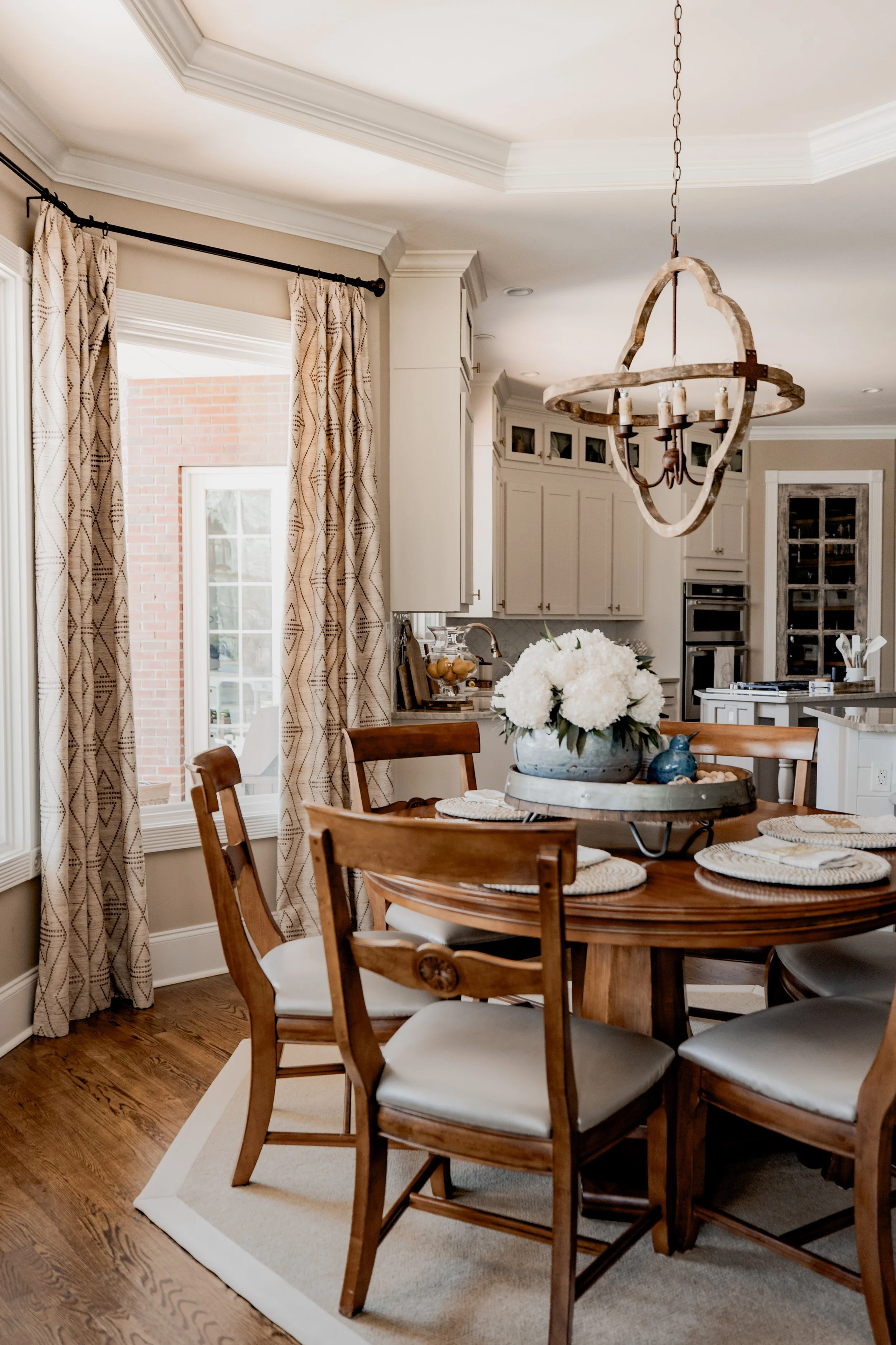 An inviting eat-in kitchen dining area designed by Cossart Design, blending comfort and style with elegant finishes, custom window treatments, and tailored furniture. This casual dining space enhances everyday life while maintaining a luxurious and c