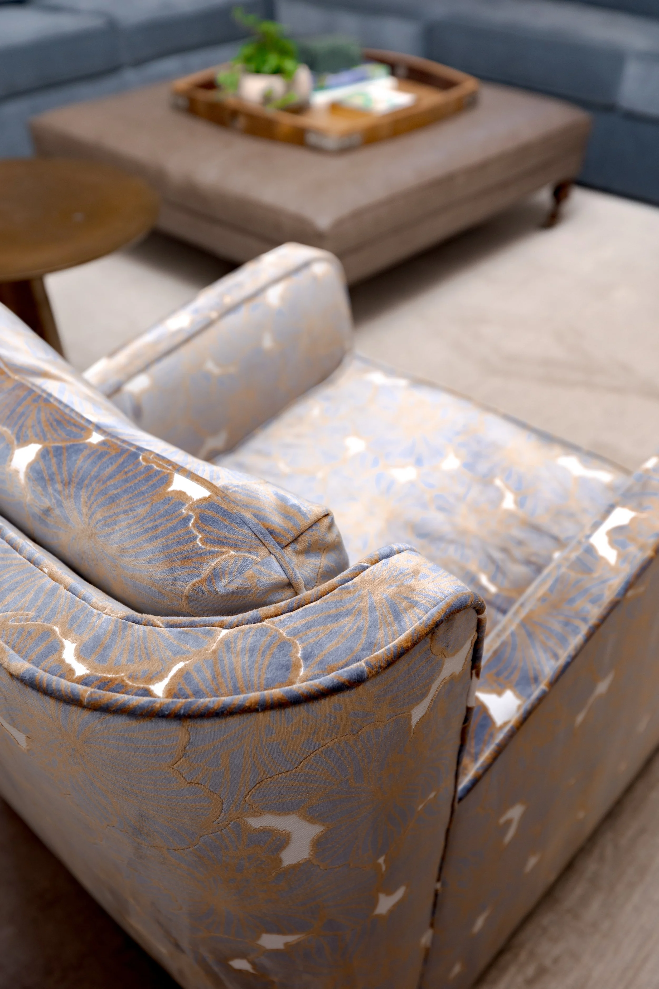 An inviting main living space layered with natural textures, warm wood tones, and classic finishes. Custom chairs and sofa by Cossart Design elevates the functionality with style.  Designed to support real life, this space feels connected, comfortabl