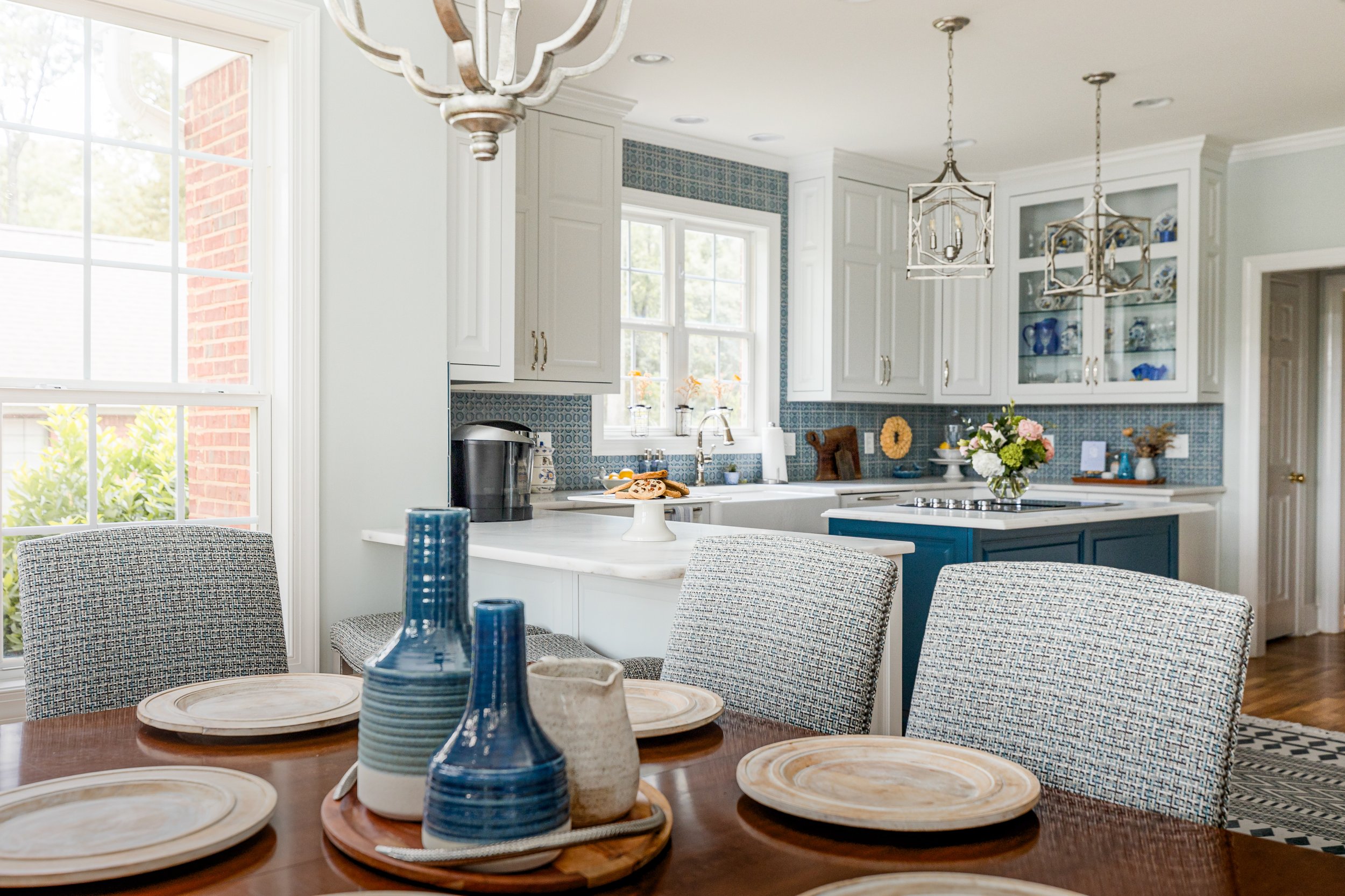 A sunlit eat-in dining area by Cossart Design, featuring expansive windows, elegant furnishings, and thoughtful details that create a bright, inviting space for meals and gatherings. The design balances Southern charm with elevated style, perfect for