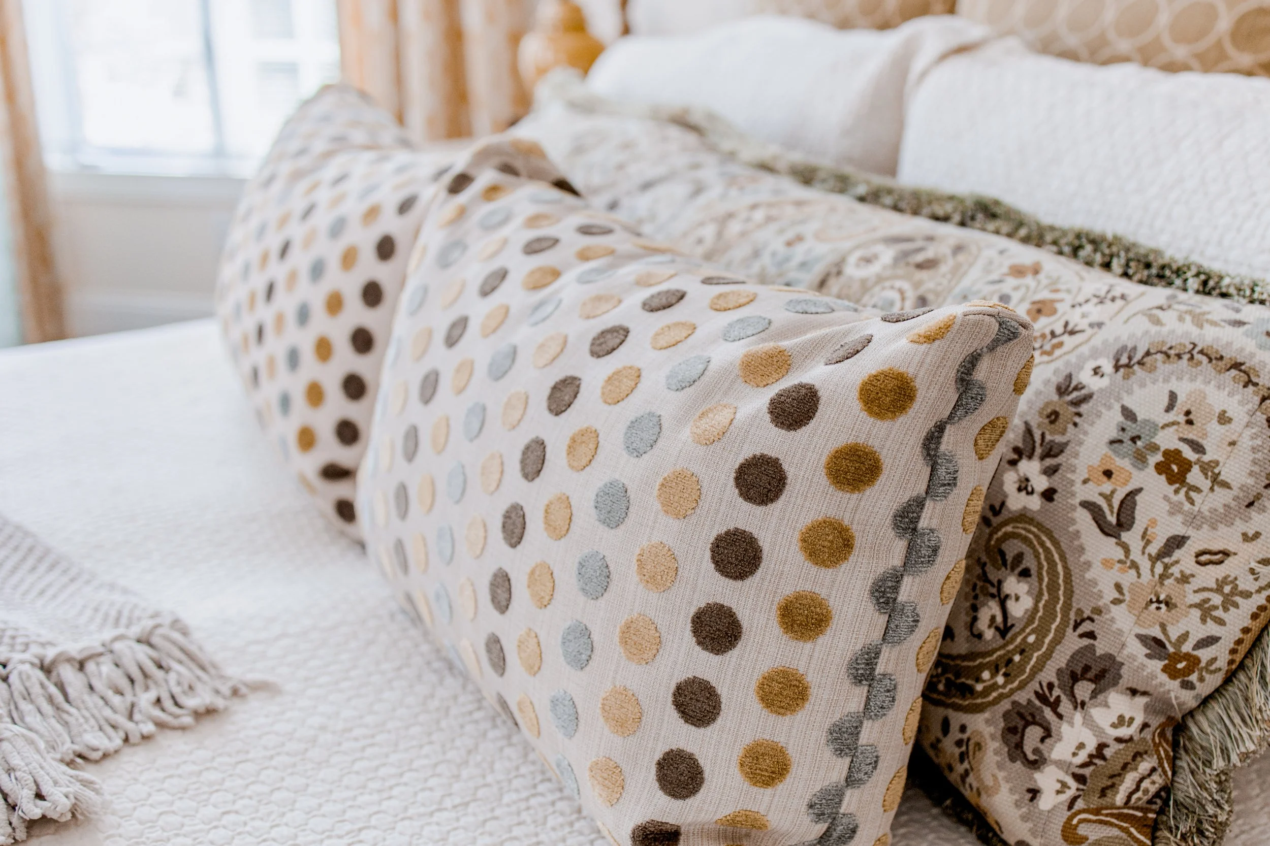 A serene and luxurious master bedroom designed by Cossart Design, featuring layered textures, custom bedding, and thoughtfully curated furnishings. The space balances elegance and comfort with warm tones, soft lighting, and functional seating areas t