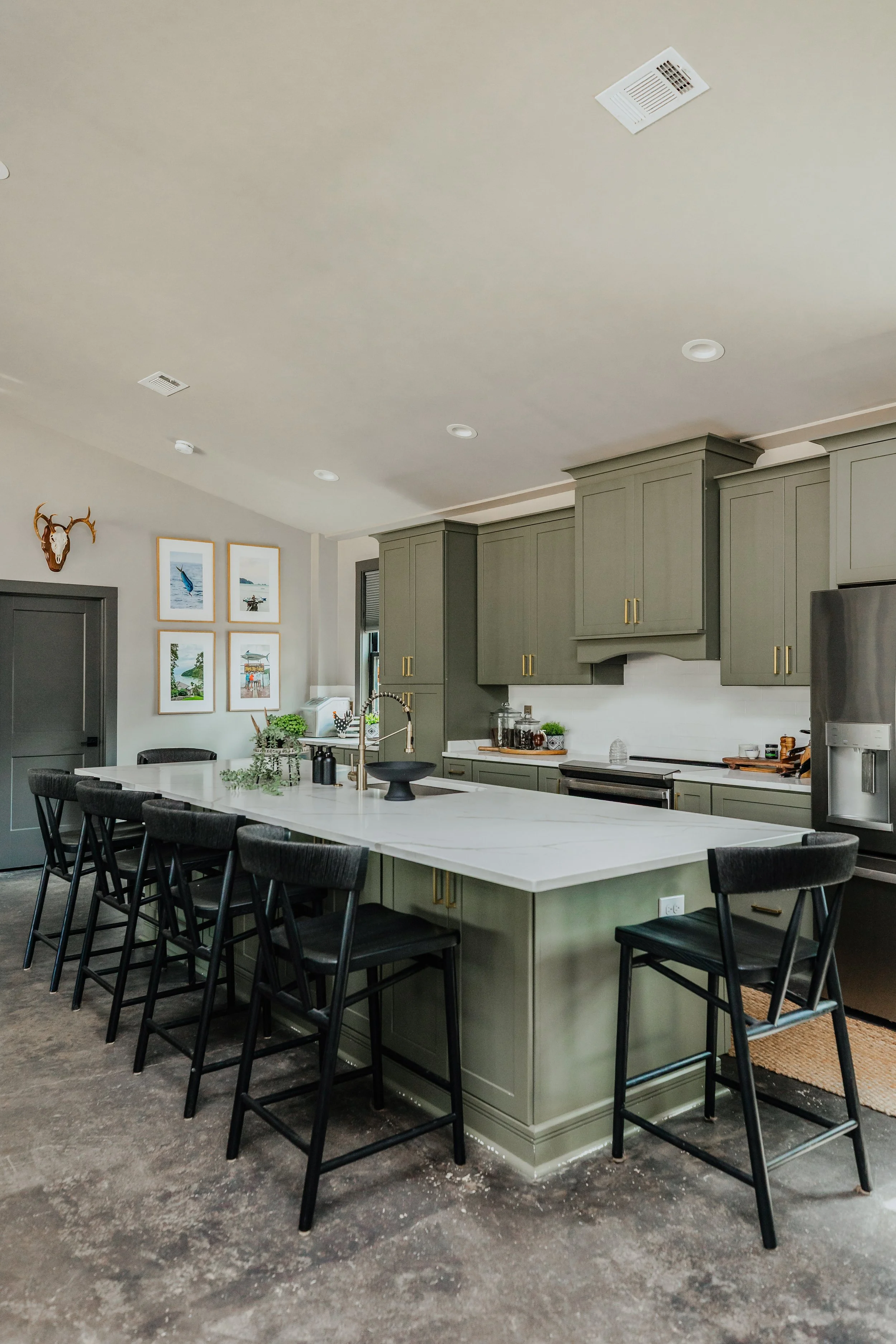 An open kitchen by Cossart Design that combines rugged sensibility with refined finishes, featuring stunning countertops and a custom backsplash that elevate the space. Industrial accents pair with sleek surfaces and thoughtfully selected materials t