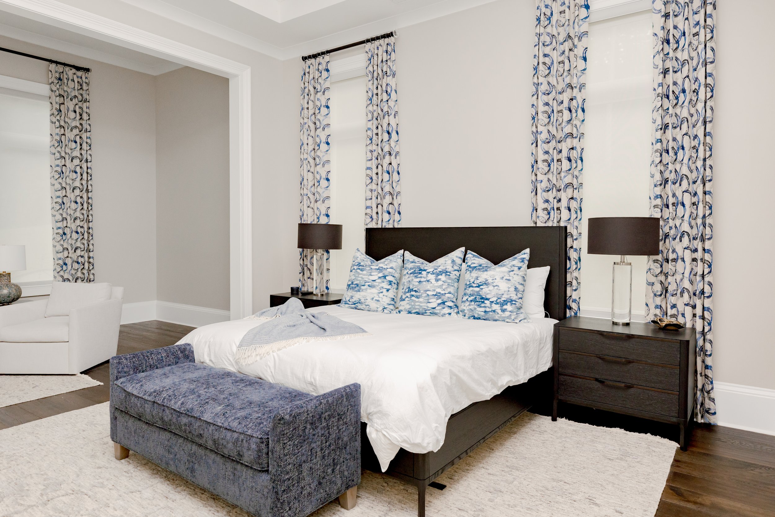 A serene master bedroom retreat designed to feel calming, refined, and restorative. Custom bedding, tailored window treatments, and motorized shades create a luxurious yet peaceful environment. Soft textures and intentional layering support daily com