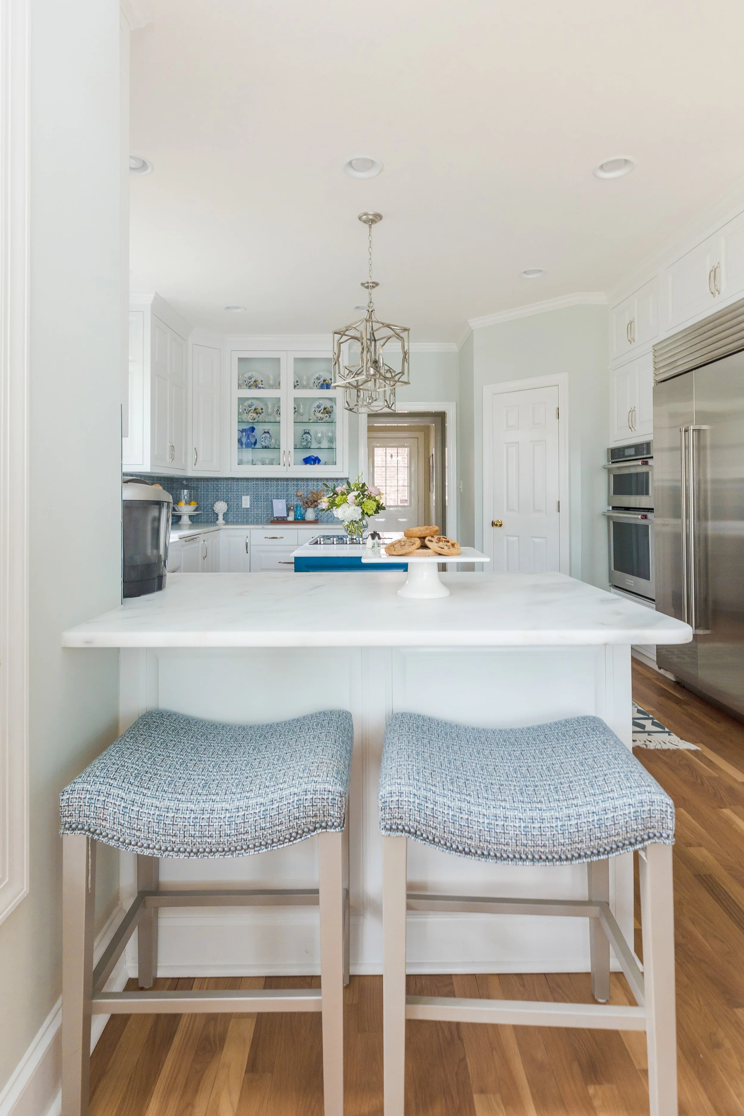 A sunlit eat-in dining area by Cossart Design, featuring expansive windows, elegant furnishings, and thoughtful details that create a bright, inviting space for meals and gatherings. The design balances Southern charm with elevated style, perfect for