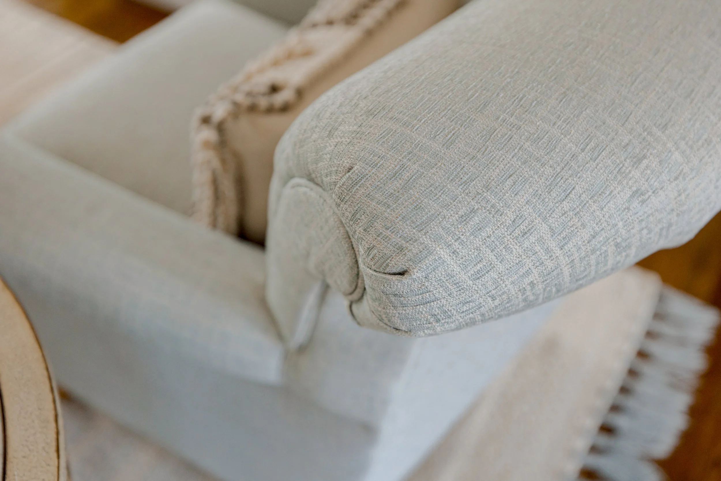 A sophisticated formal living room designed by Cossart Design, anchored by a dramatic floor-to-ceiling fireplace and custom furnishings that combine style and comfort. The space is layered with textures, tailored seating, and carefully chosen accent 