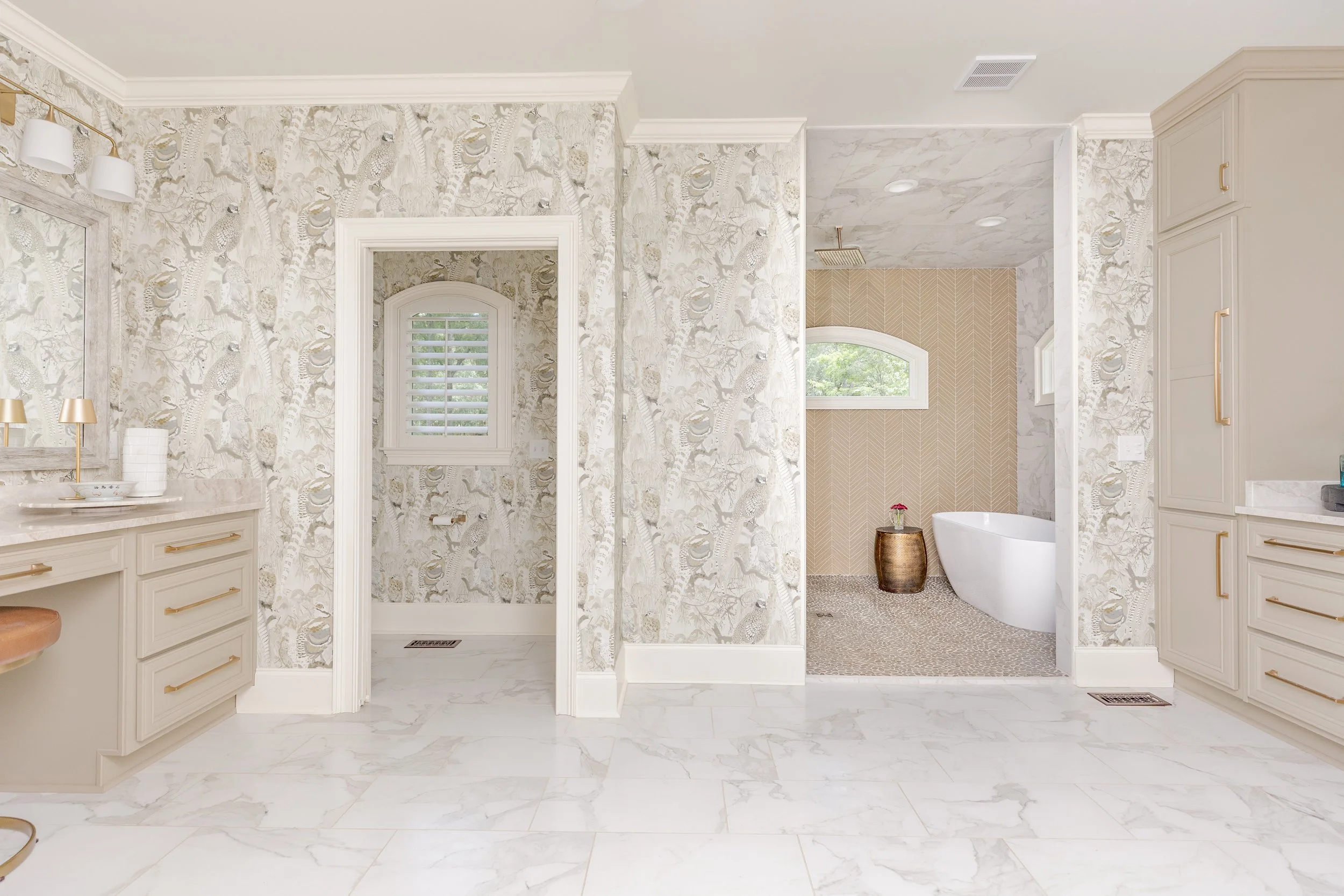 A spa-inspired primary bathroom designed for relaxation and daily ritual. Elevated materials, balanced lighting, and thoughtful layouts create a space that feels calming, timeless, and refined. The textured wallpaper custom tile, and gold finishes br