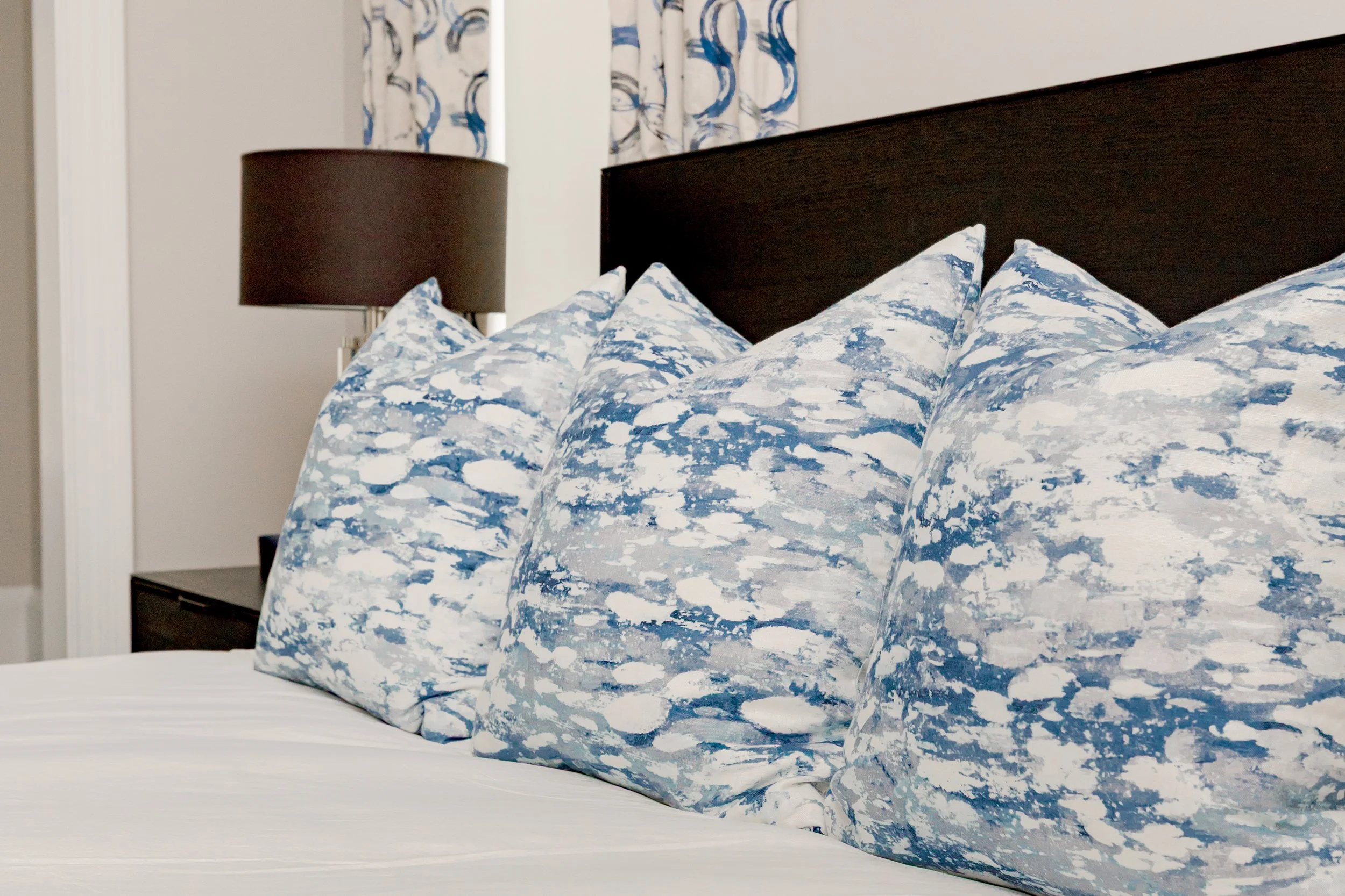 A serene master bedroom retreat designed to feel calming, refined, and restorative. Custom bedding, tailored window treatments, and motorized shades create a luxurious yet peaceful environment. Soft textures and intentional layering support daily com