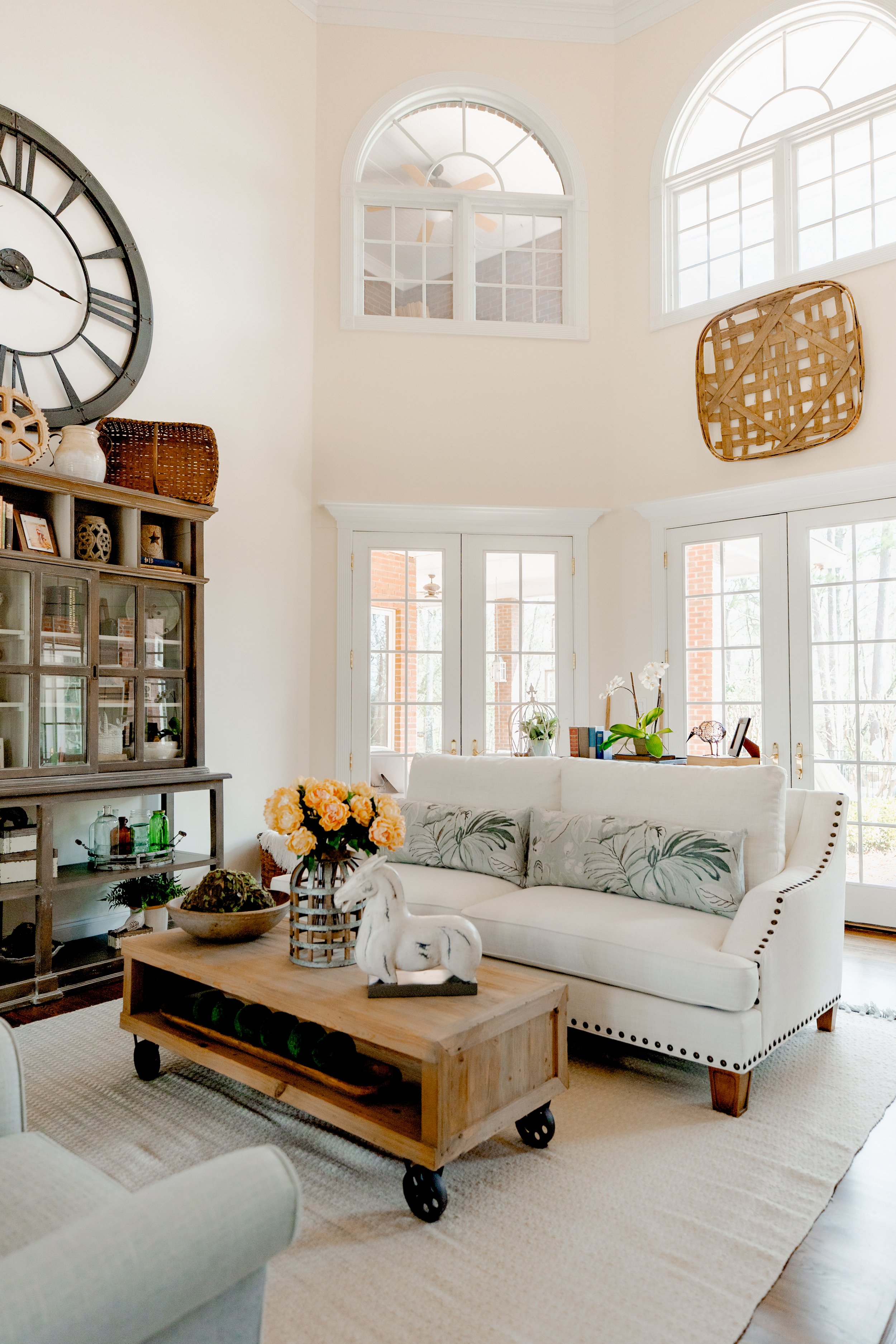 A sophisticated formal living room designed by Cossart Design, anchored by a dramatic floor-to-ceiling fireplace and custom furnishings that combine style and comfort. The space is layered with textures, tailored seating, and carefully chosen accent 