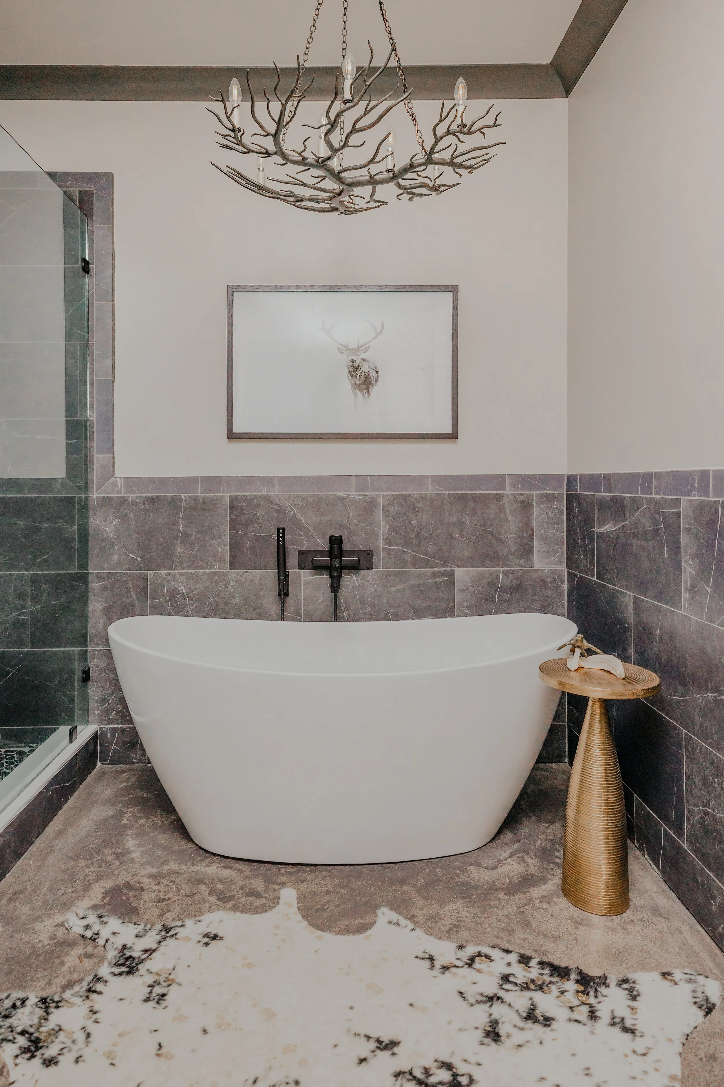 A luxury bathroom with deep soaking tub carefully designed by Cossart Design that balances rugged elegance with spa‑like comfort. Custom tilework, refined fixtures, and tailored finishes create a serene space that feels both elevated and purposeful. 