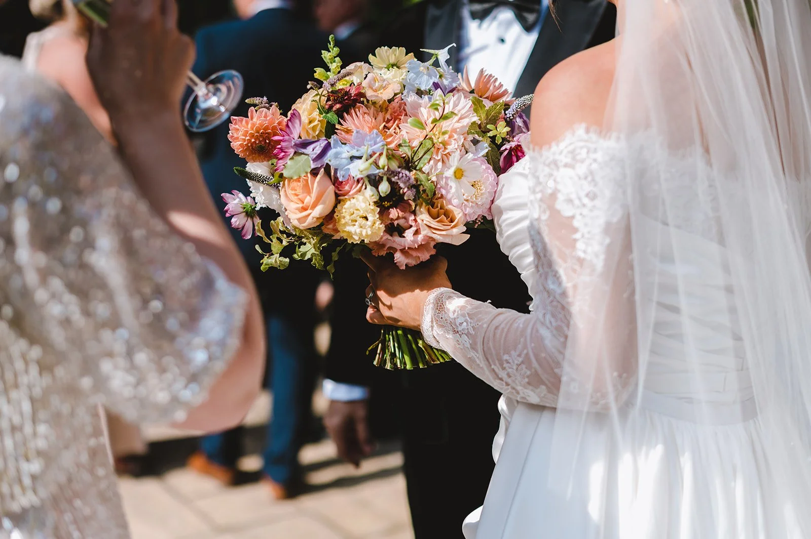 A bride holding a colorful bouquet of flowers at a wedding ceremony.