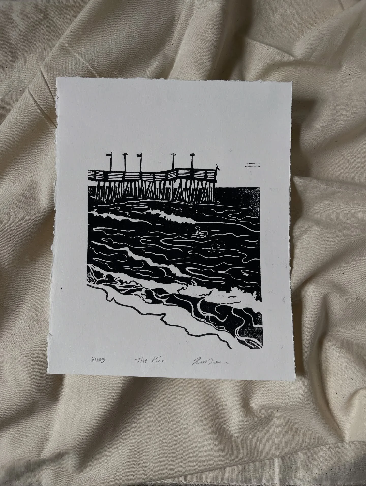&ldquo;The Pier&rdquo; 

This Lino block was inspired by the families first trip to the ocean front in the spring. My goal was to capture the landmark of our coastline and the energy of the people who visit. 

8x10&rdquo; 
Lino print (three paper cho