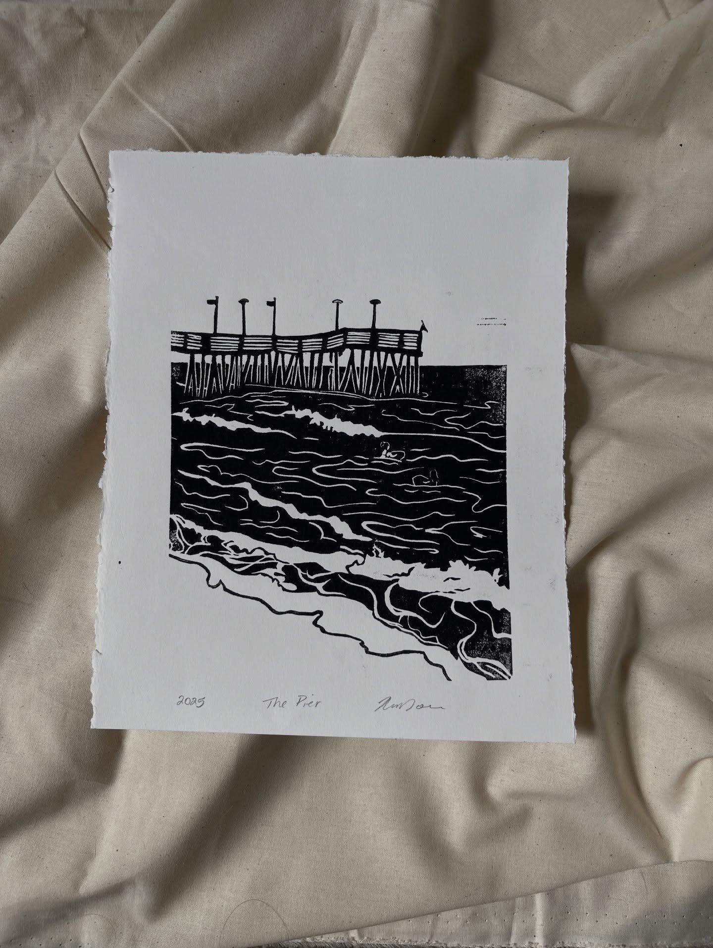 &ldquo;The Pier&rdquo; 

This Lino block was inspired by the families first trip to the ocean front in the spring. My goal was to capture the landmark of our coastline and the energy of the people who visit. 

8x10&rdquo; 
Lino print (three paper cho