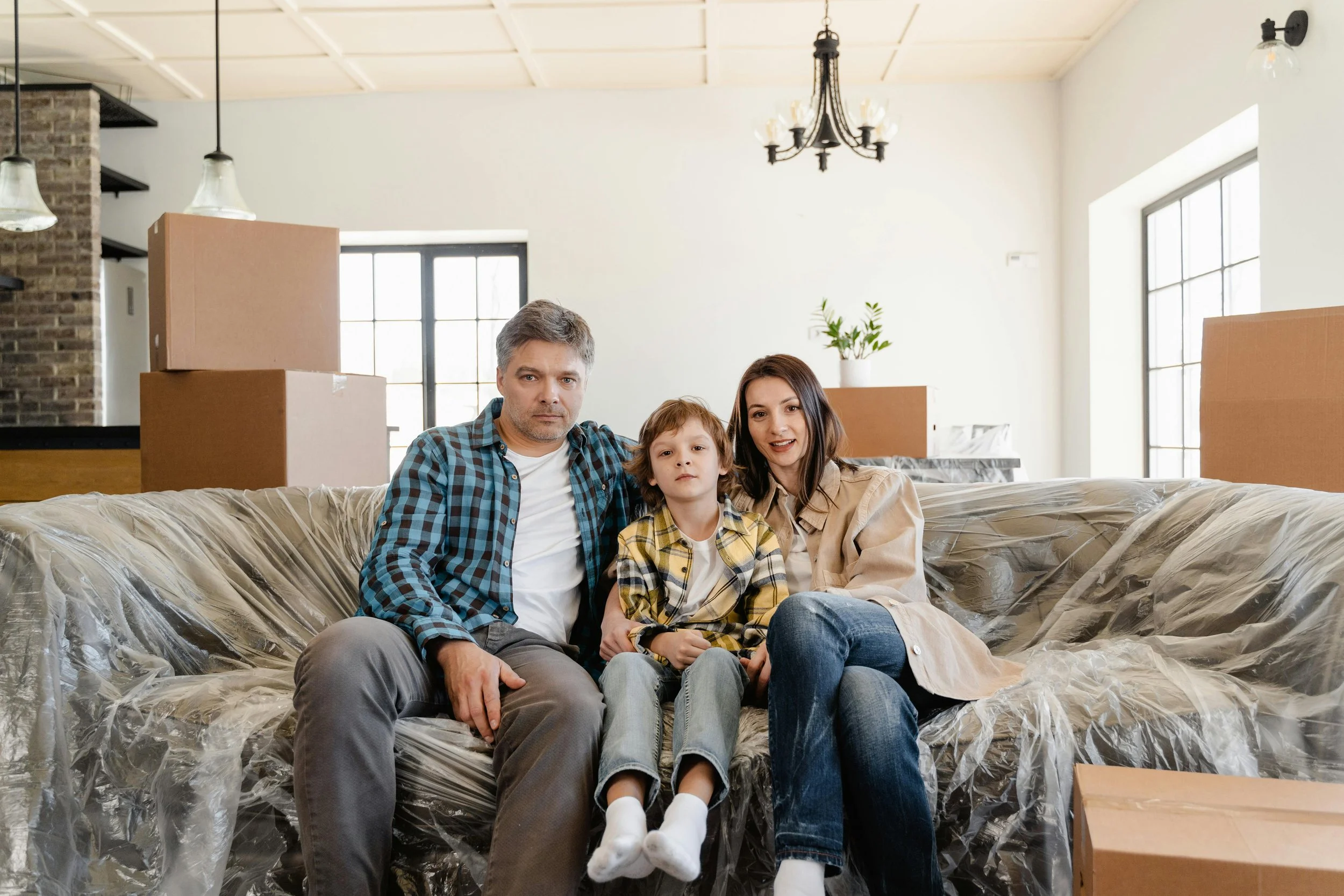 Famille assise sur un canapé dans un salon en cours de déménagement.