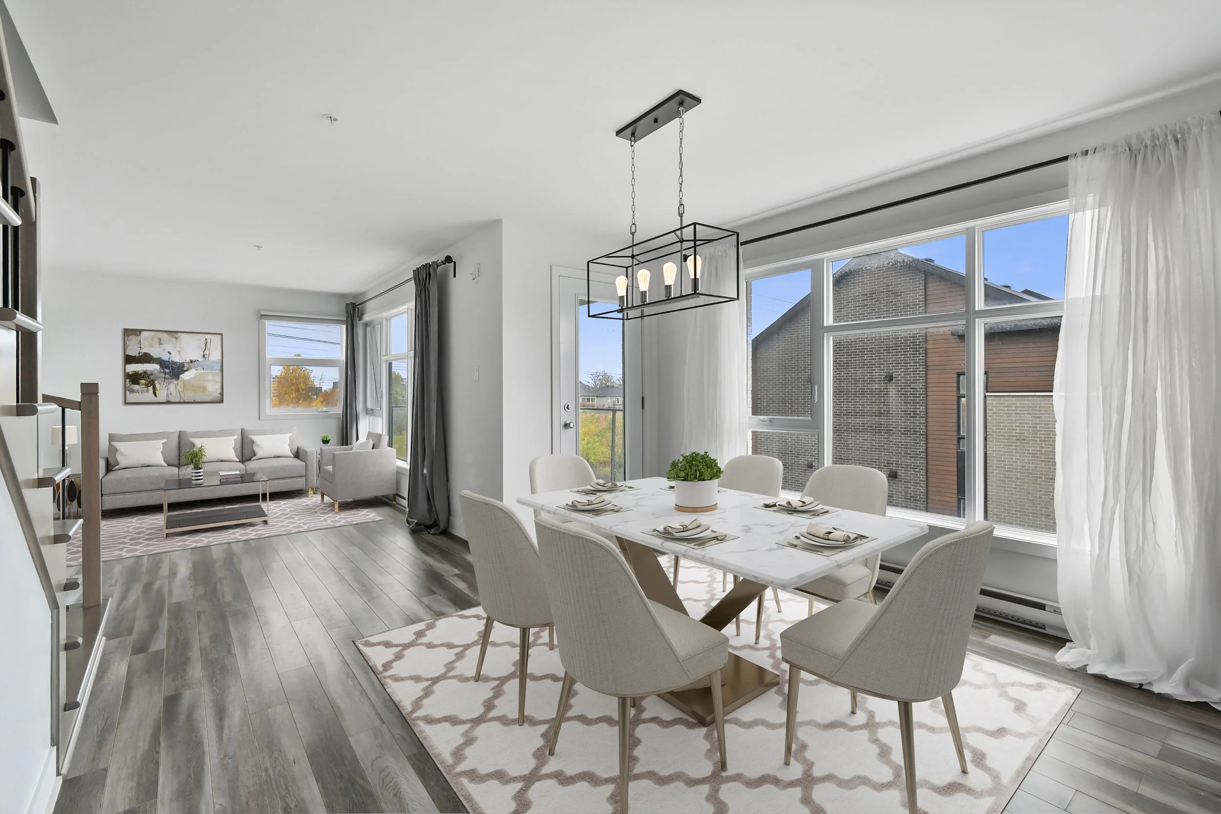 Salon et salle à manger modernes avec grande fenestration, meubles en tissu clair,et décoration neutre, dans un intérieur lumineux.