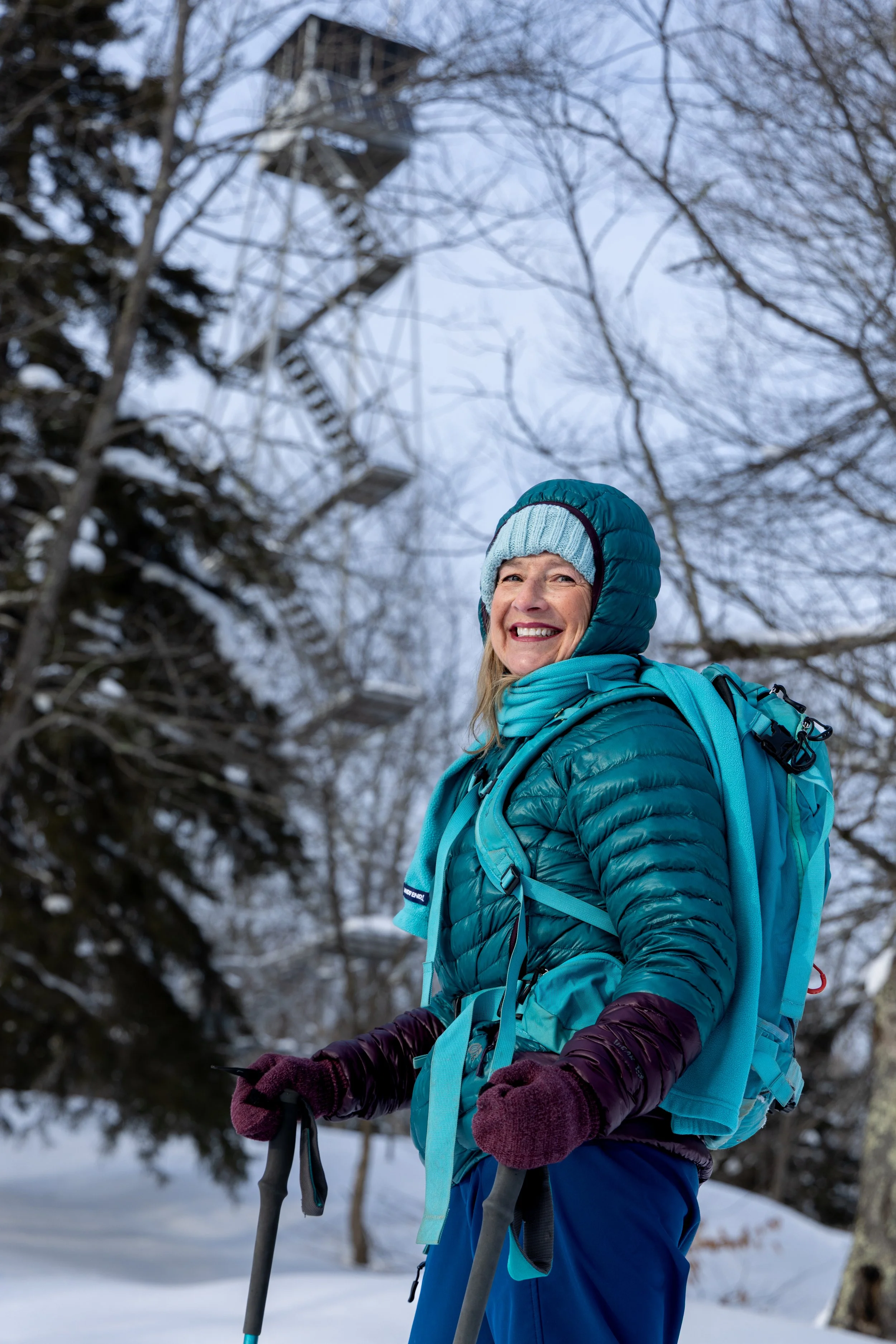 Paula Brown, 46er and Winter 46er in front of Kane Firetower where she stewards in the summer, NY