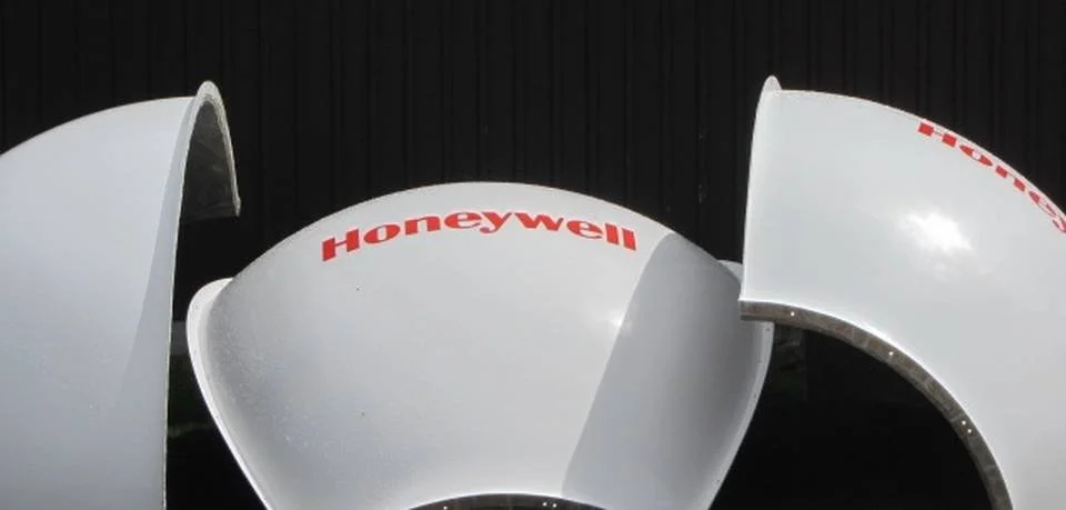 Three large white HVAC or industrial ventilation fans stacked outdoors, with the brand name 'Honeywell' in red letters on each fan.