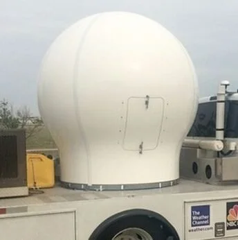 A large white weather radar dome on a truck in an outdoor setting.