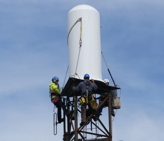 Radome maintenance workers installing radome on tower