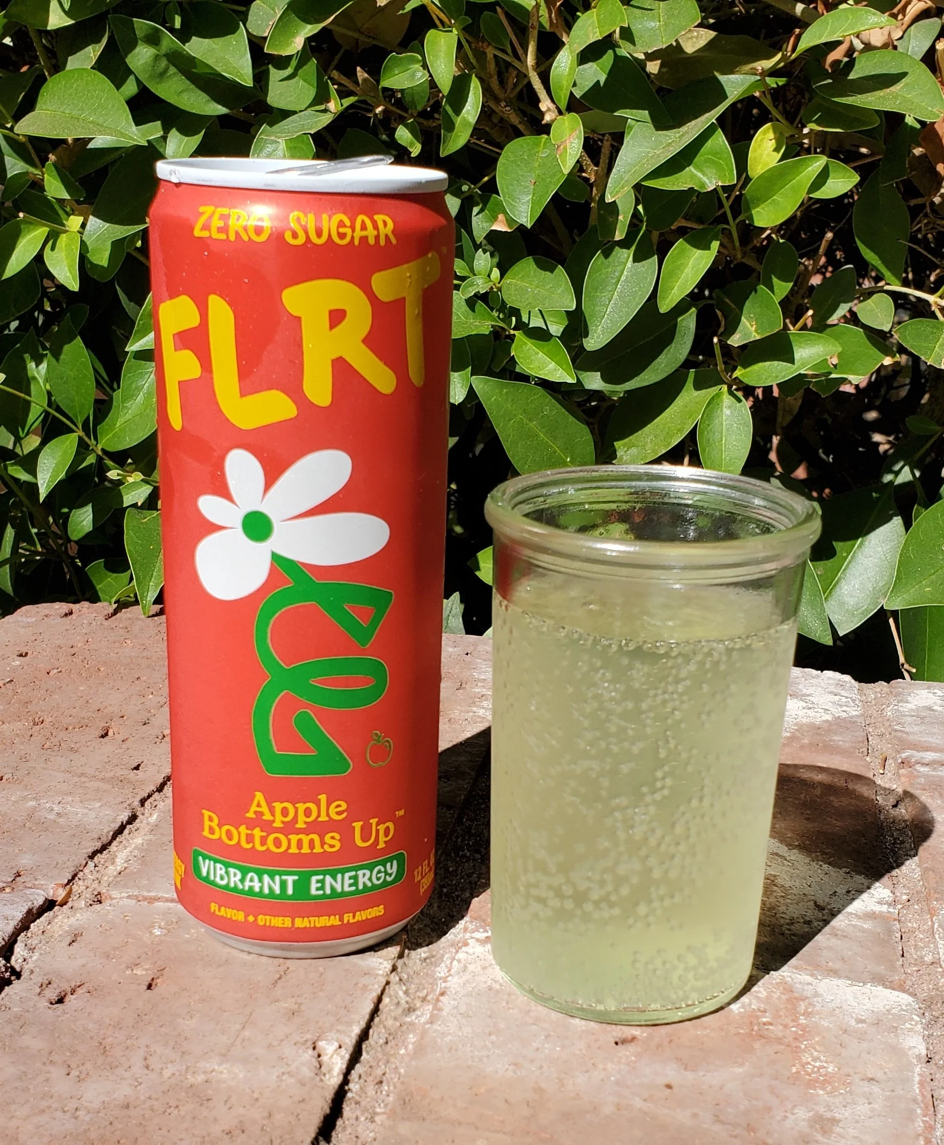 Cold can of FLRT apple Energy drink and a glass