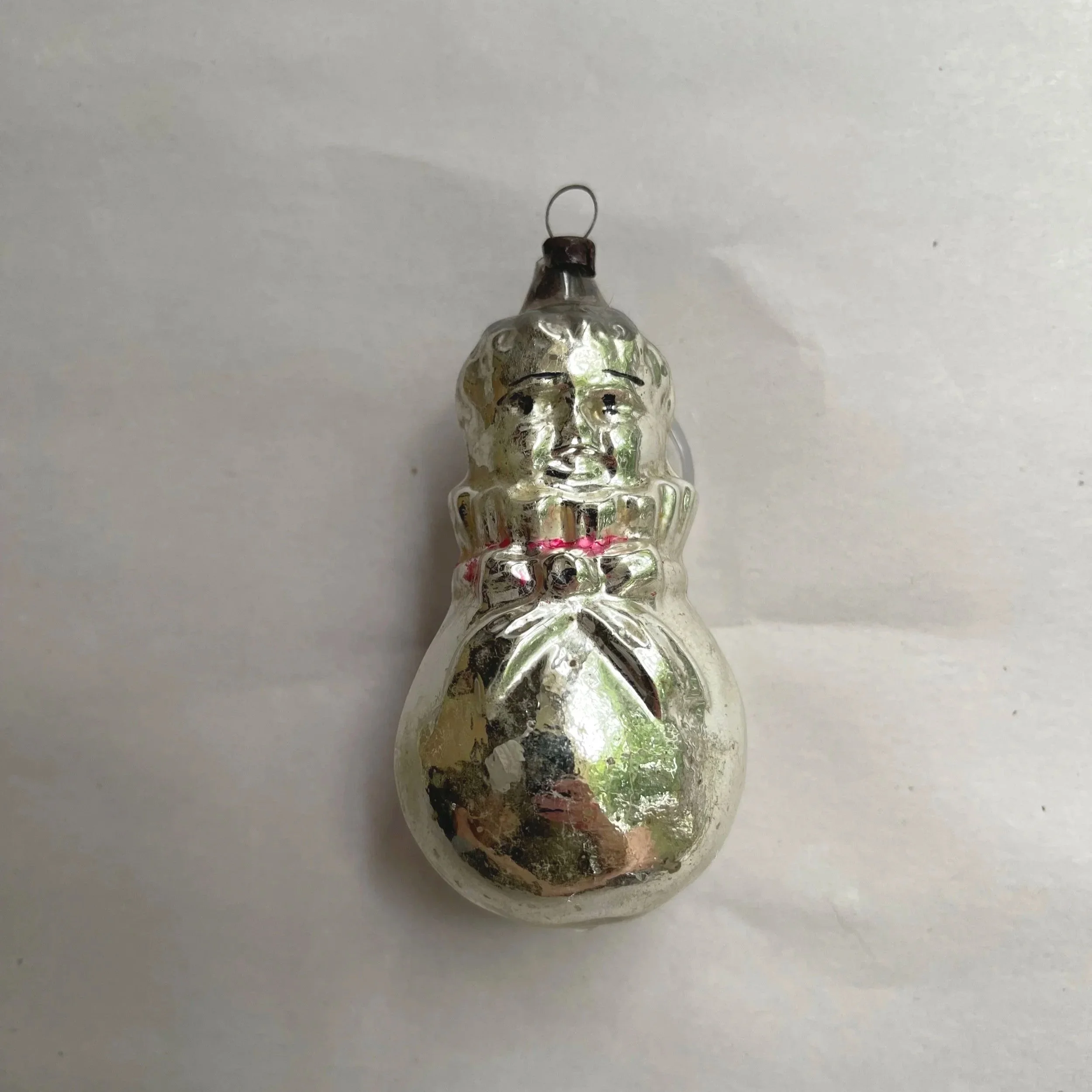 Antique German molded-glass baby-in-bunting Christmas ornament with a silvered finish.