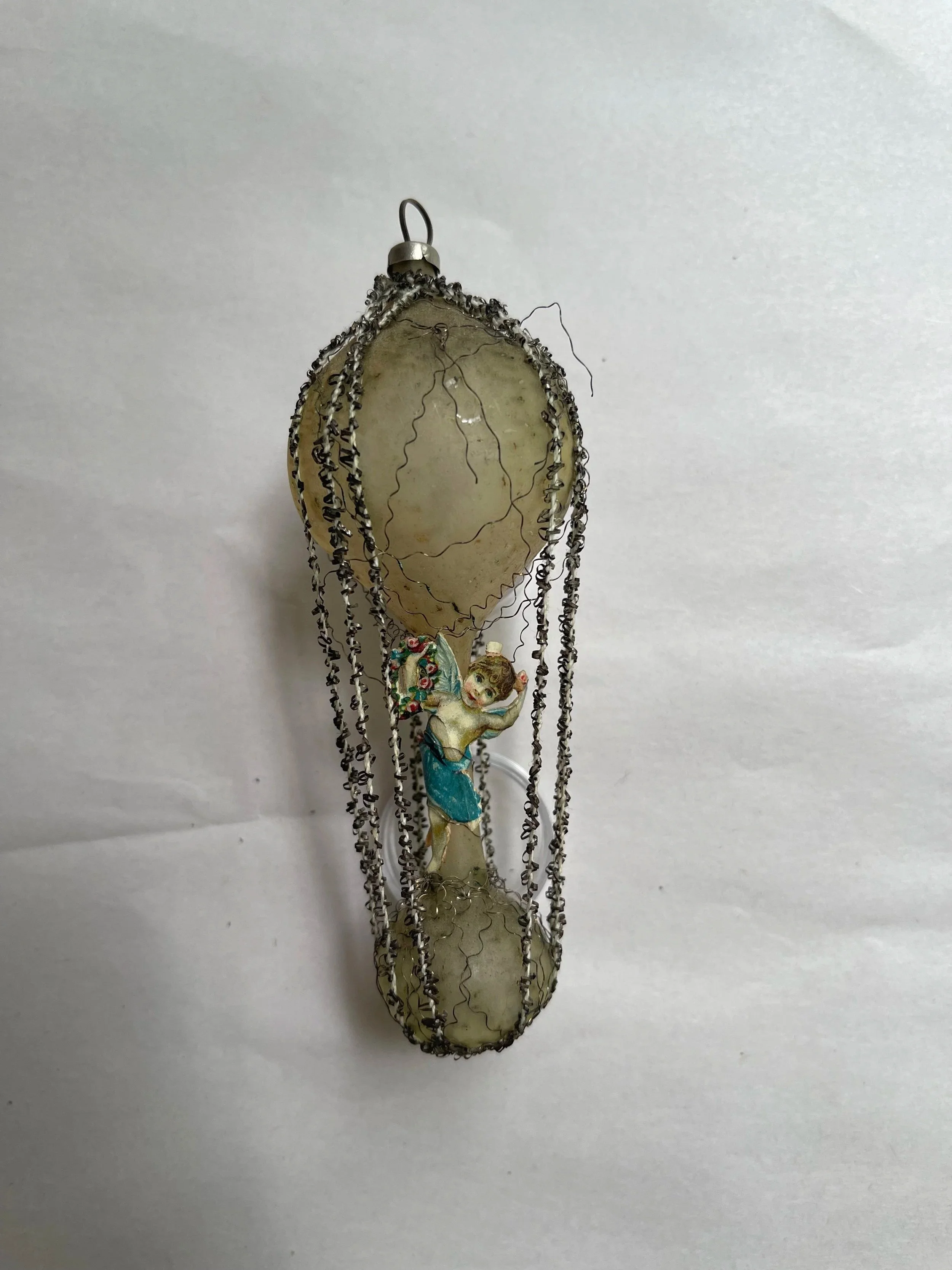 Antique German wire-wrapped glass hot-air-balloon ornament with a cherub decoration.